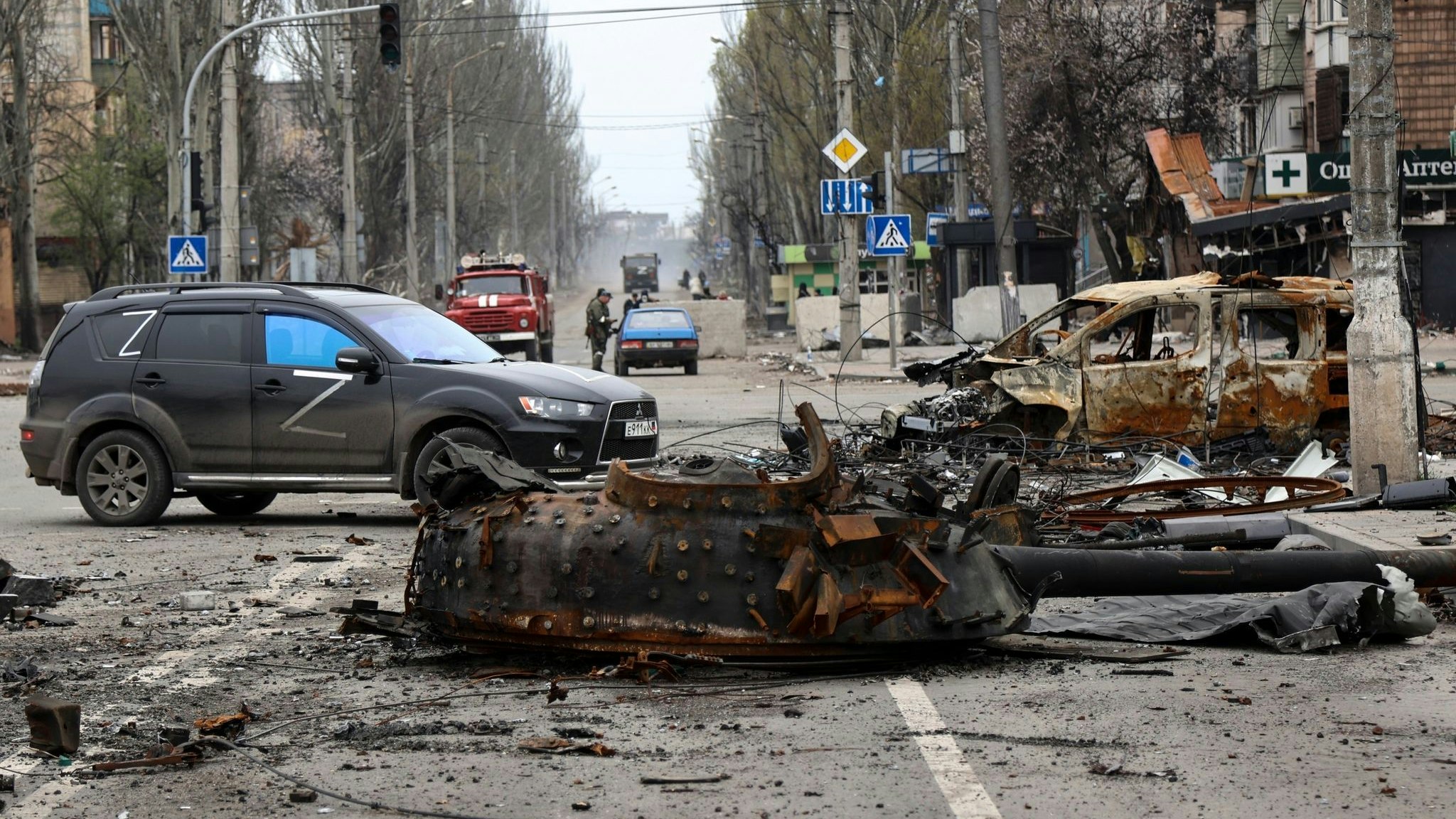 Ein Teil eines zerstörten Panzers und ein verbranntes Fahrzeug auf einer Straße in Mariupol. Foto: dpa/AP/Alexandrov