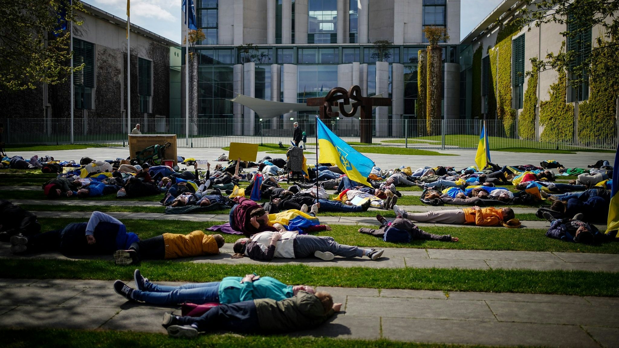 Auf dem Boden liegend protestieren diese Menschen vor dem Bundeskanzleramt gegen den Krieg in der Ukraine. Foto: dpa/Nietfeld