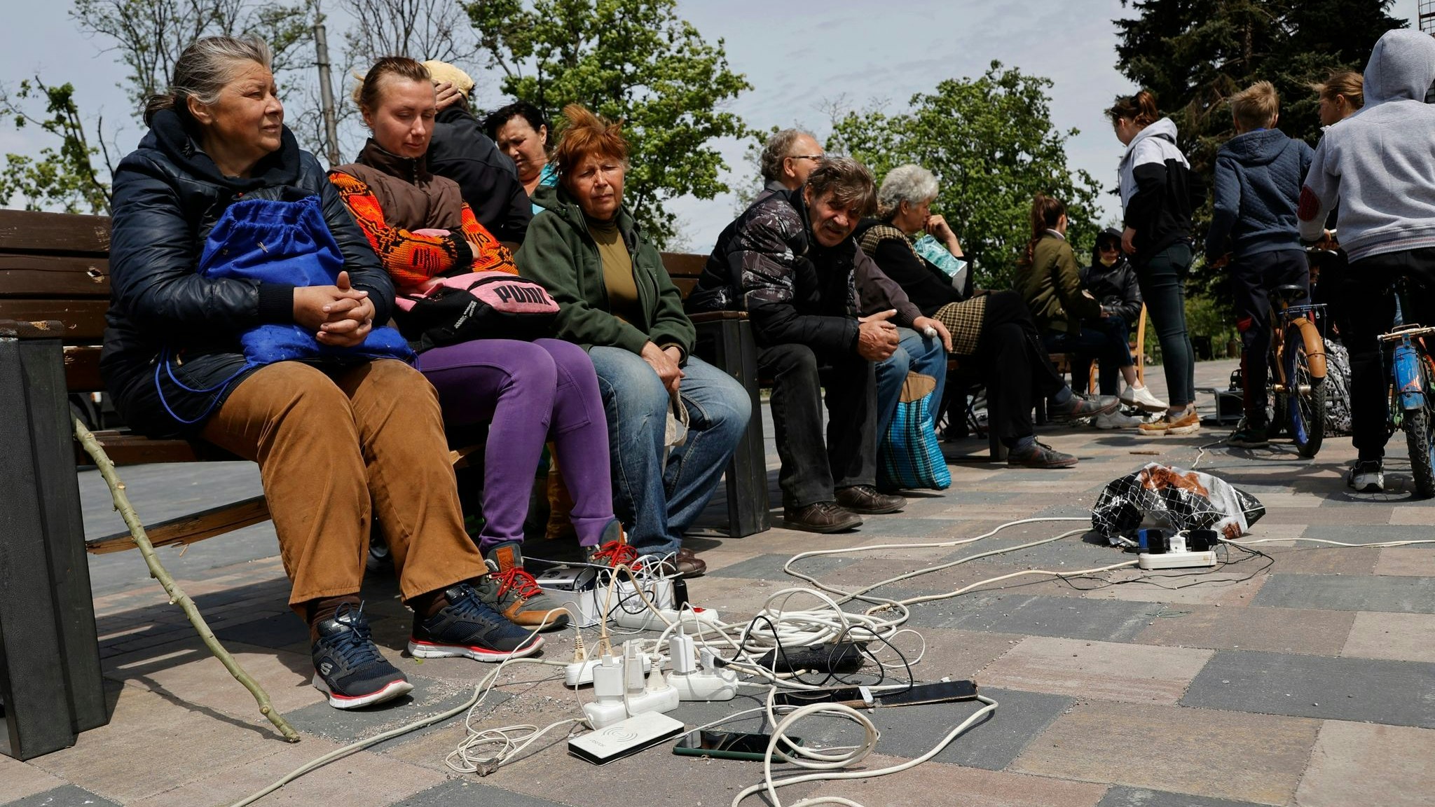 Menschen in Mariupol laden ihre Telefone auf - das Gebiet in der Ostukraine steht unter der Regierung der sogenannten Donezker Volksrepublik. Foto: Alexei Alexandrov / AP / dpa