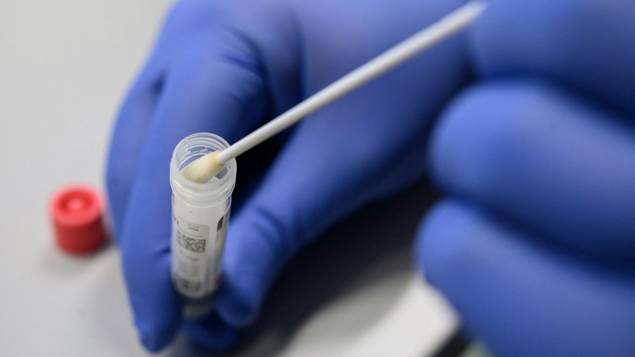 Ein Mann zeigt einen Abstrich für das Testverfahren auf das Virus Sars-CoV-2. Foto: dpa/Gollnow