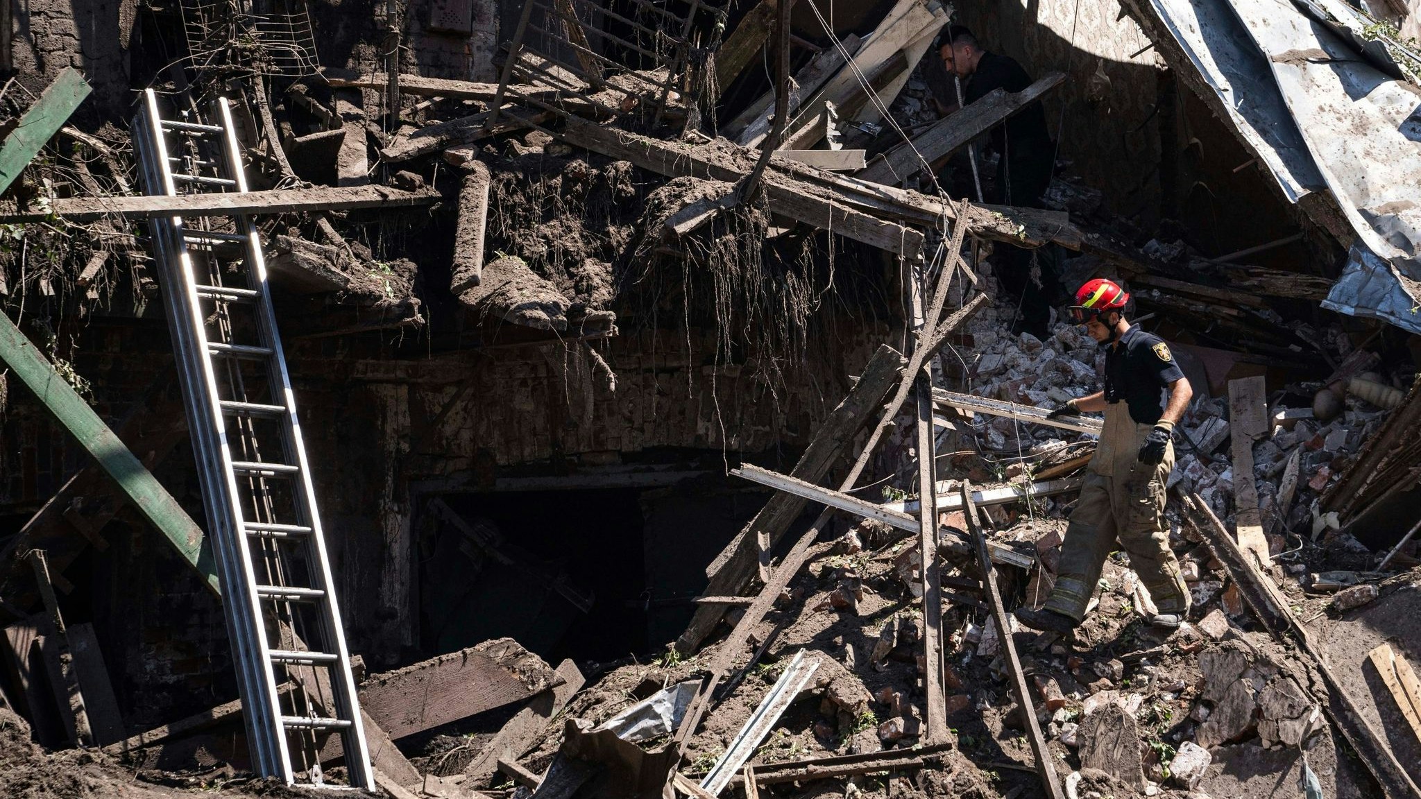 Rettungskräfte und Polizisten inspizieren ein zerstörtes Haus nach einem russischen Angriff in einem Wohnviertel in der Innenstadt von Charkiw. Foto: dpa/Maloletka