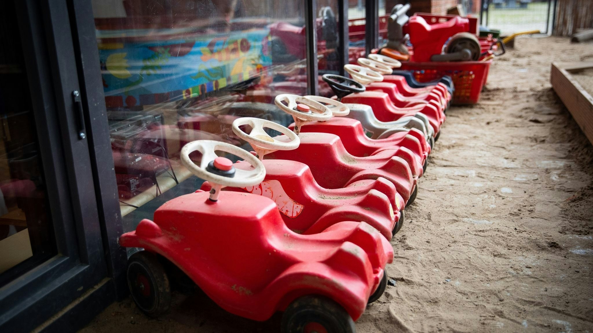 Mehrere Bobbycars stehen auf dem Spielplatz eines Kindergartens. Foto: dpa/Charisius