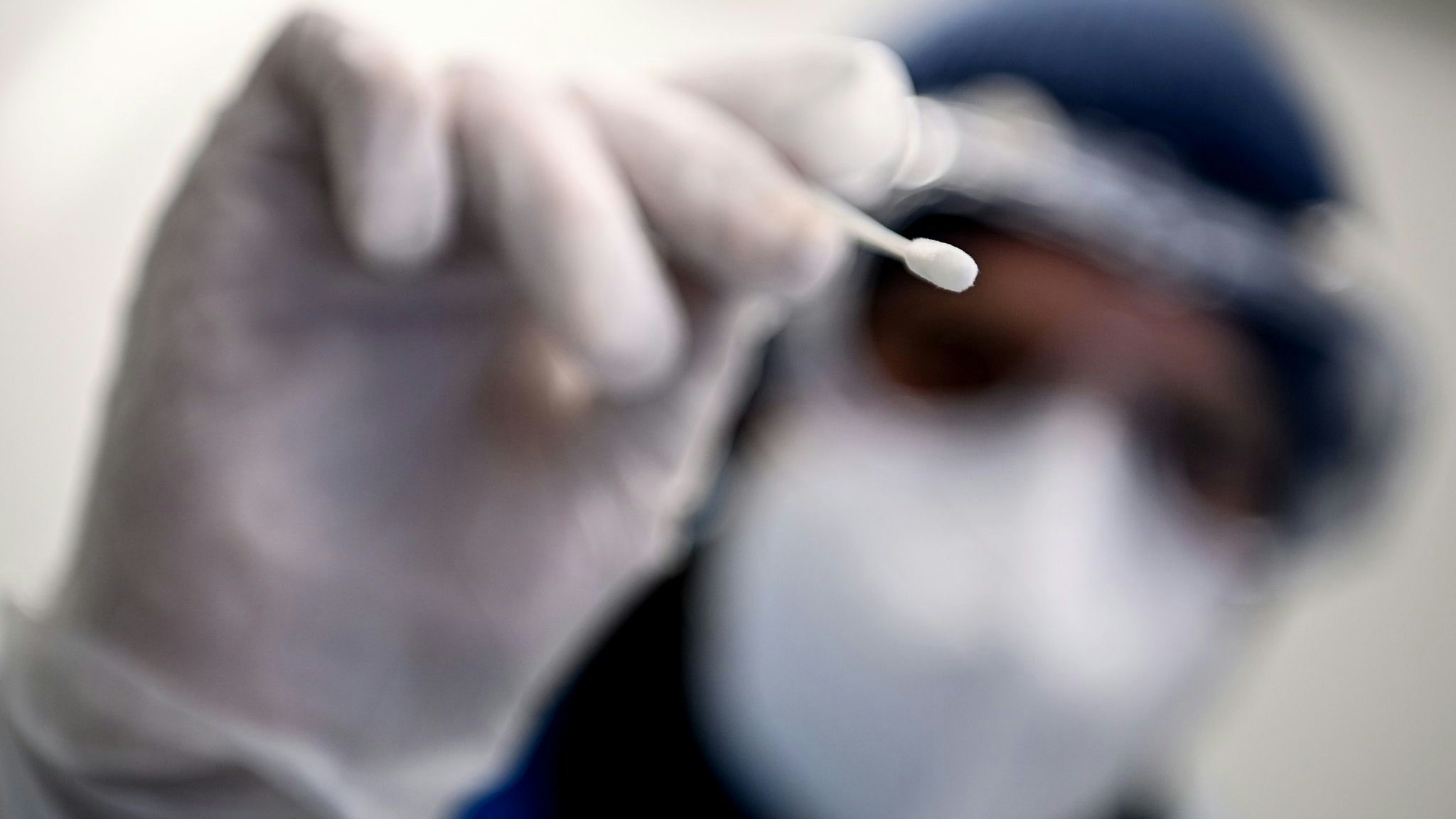 Ein Arzt hält ein Teststäbchen für die Entnahme einer Probe für einen Corona-Test in der Hand. Foto: dpa/Pedersen