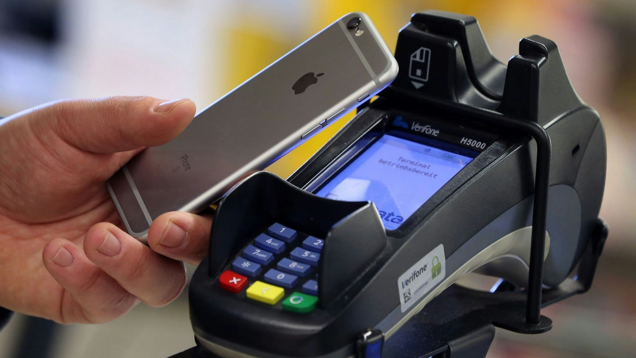 Ein Mann bezahlt mit seinem Smartphone kontaktlos in einem Supermarkt. Foto: dpa/Hildebrand