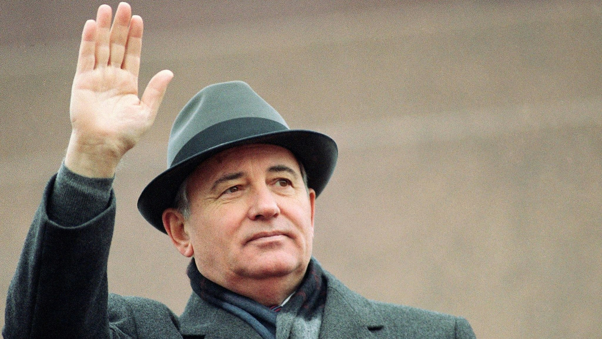 Michail Gorbatschow, damals sowjetischer Präsident, winkt während einer Feier zum Tag der Revolution von der Tribüne des Roten Platzes in Moskau. Foto: dpa/Yurchenko