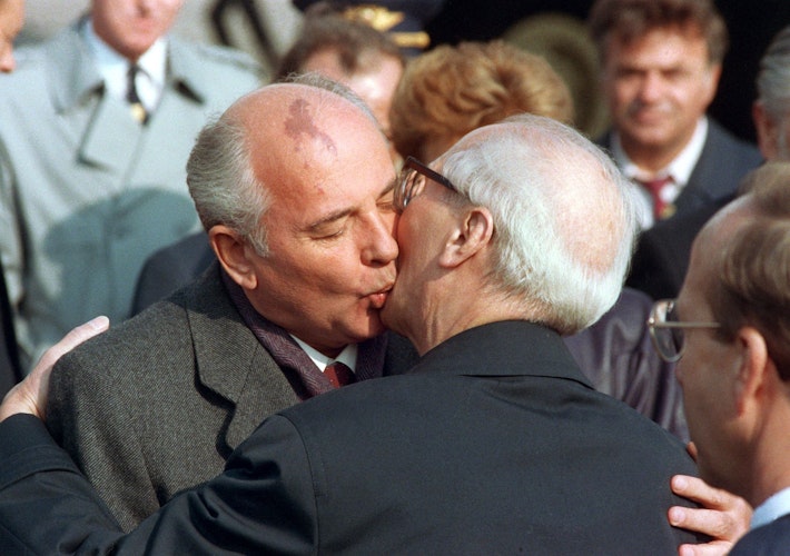 Berlin: Michail Gorbatschowb (l), Führer der Kommunistischen Partei der Sowjetunion, und Erich Honecker, Staats- und Parteichef der DDR, tauschen auf dem Ostberliner Flughafen Schönefeld einen Kuss aus. Foto: dpa