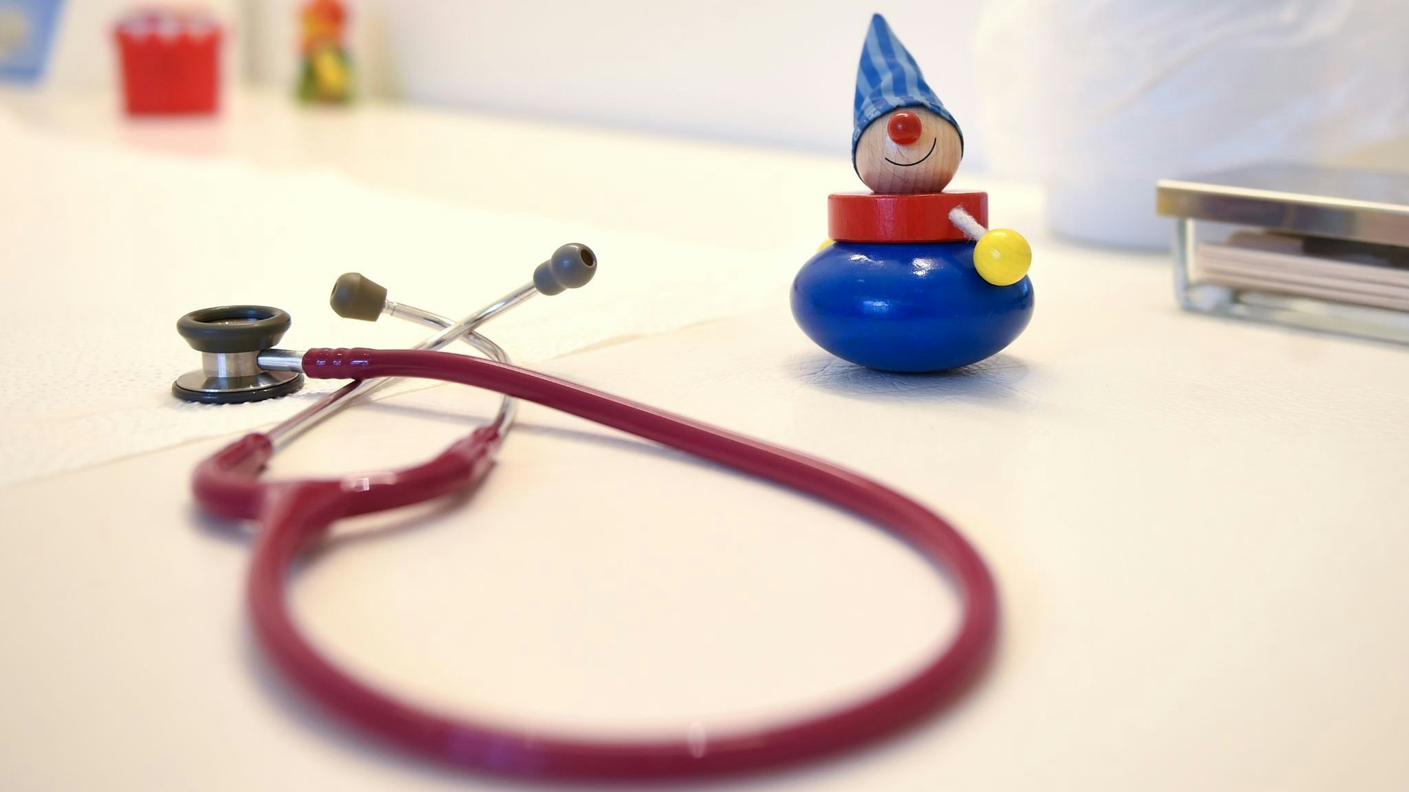 Ein Stethoskop und Kinderspielzeug liegen in einer Kinderarztpraxis auf einem Tisch. Foto: dpa/Pedersen