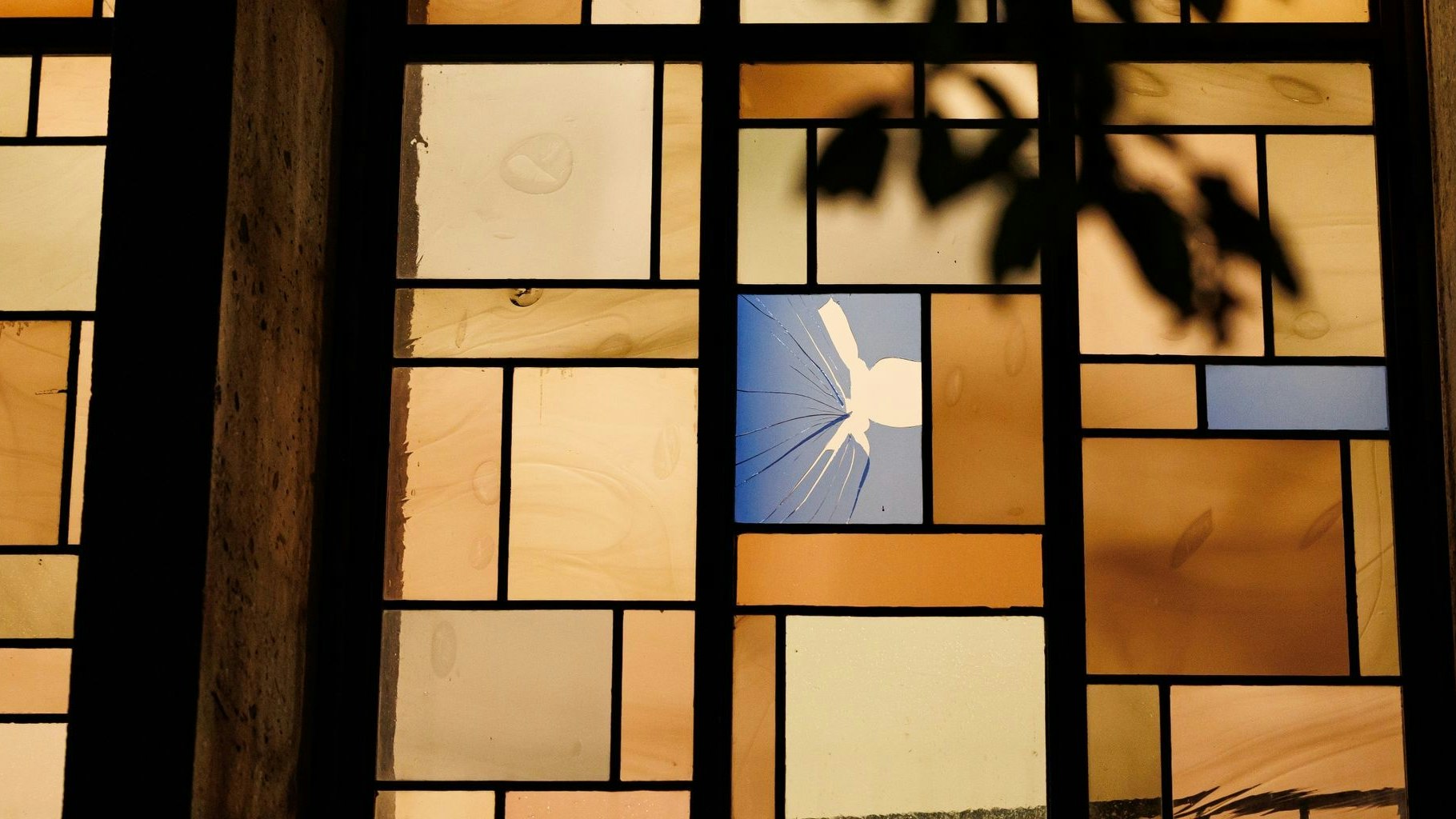 Ein beschädigtes Bleiglasfenster ist von der Außenseite der Synagoge aus zu sehen. Foto: dpa/Matthey