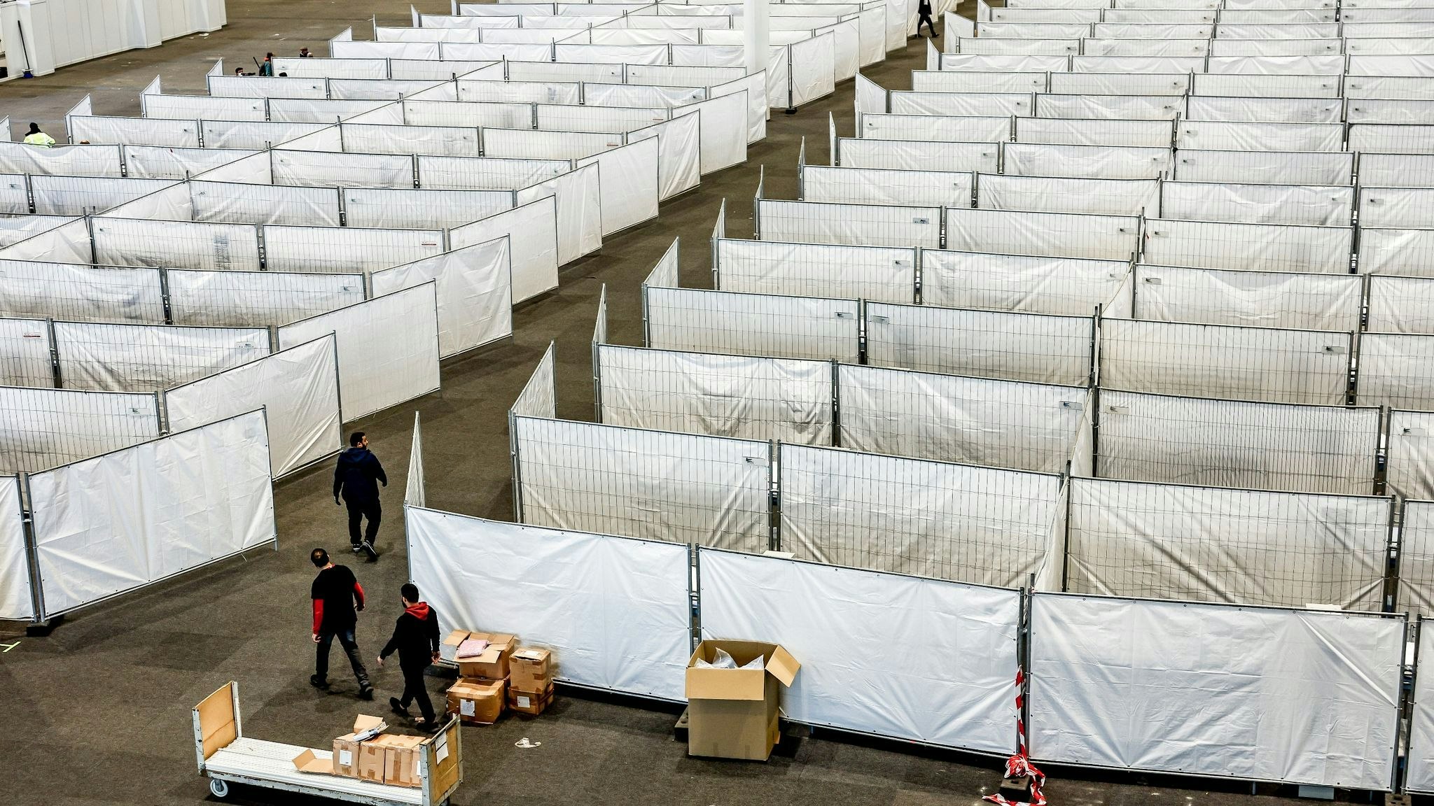Arbeiter bereiten eine Messehalle in Hamburg für die Unterbringung von Menschen aus der Ukraine vor. Dort sollen kurzfristig rund 400 Vertriebene Schutz finden. Foto: dpa/Heimken