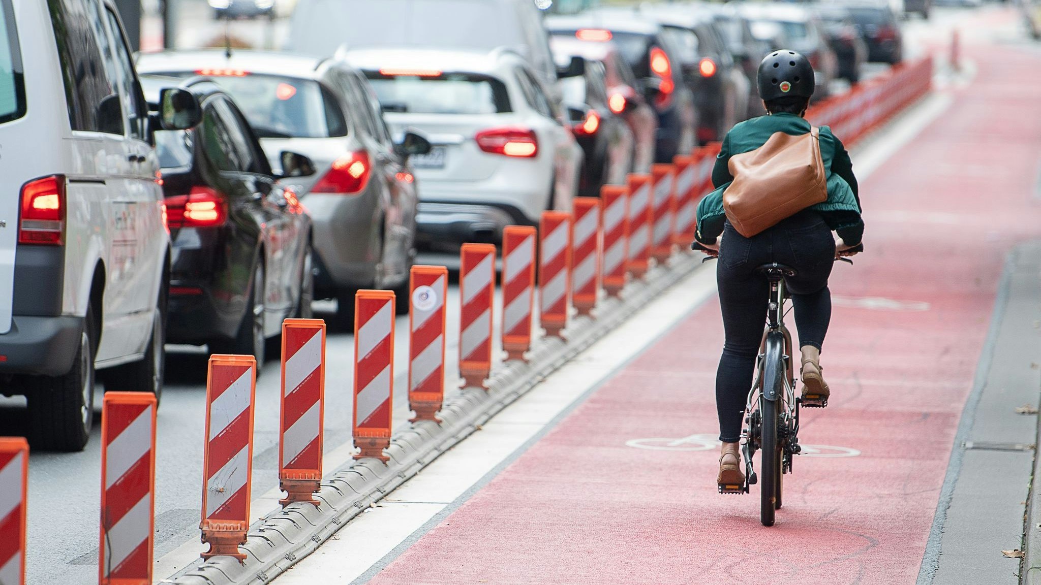 Eine Fahrradfahrerin fährt auf einer Fahrradspur an einer Straße. Die Sorge vor den Folgen der Klimakrise ist für die Menschen in Deutschland die stärkste Motivation, ihr eigenes Mobilitätsverhalten zu ändern. Foto: dpa/Gollnow