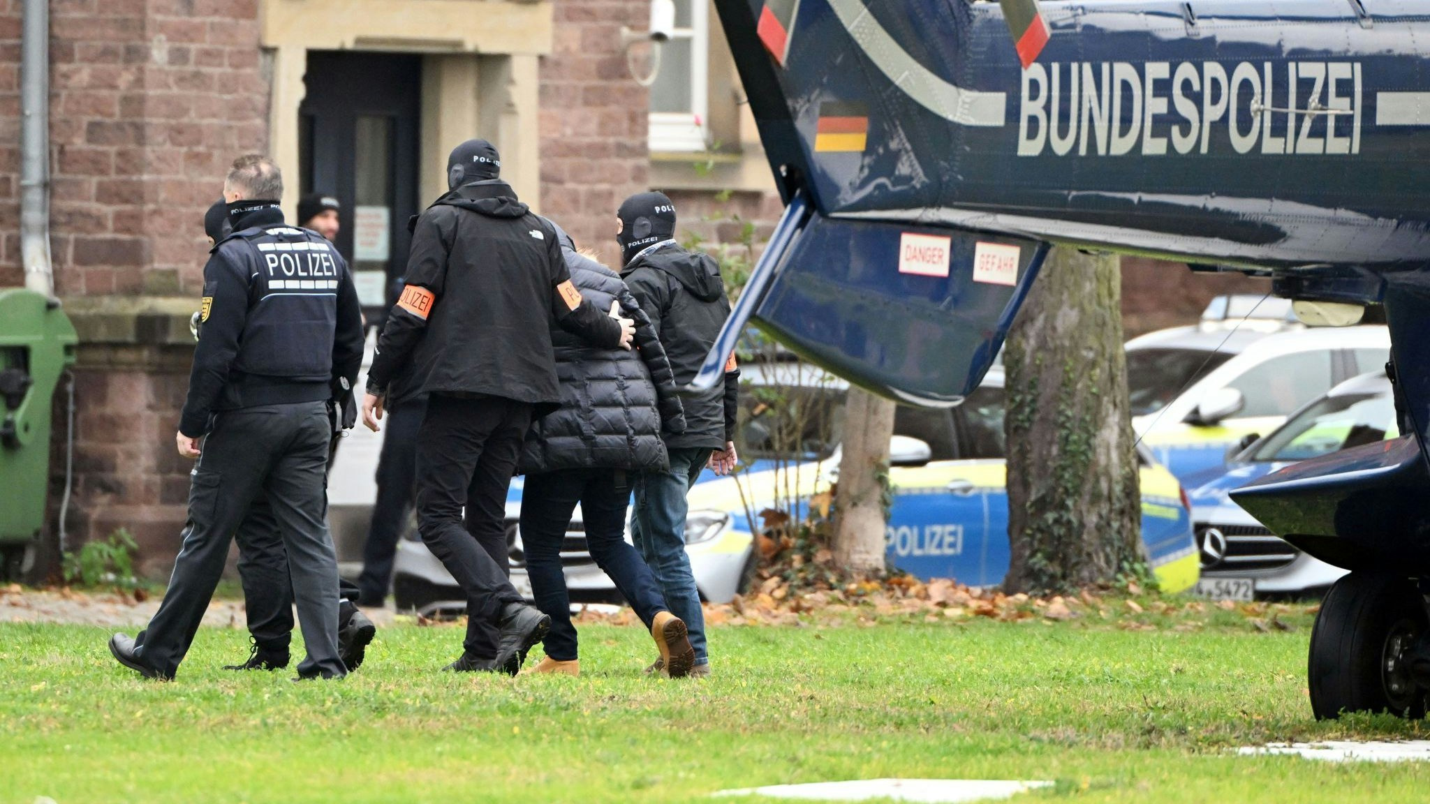 Eine festgenomene Person in Karlsruhe von Polizisten aus einem Hubschrauber gebracht. Foto: dpa