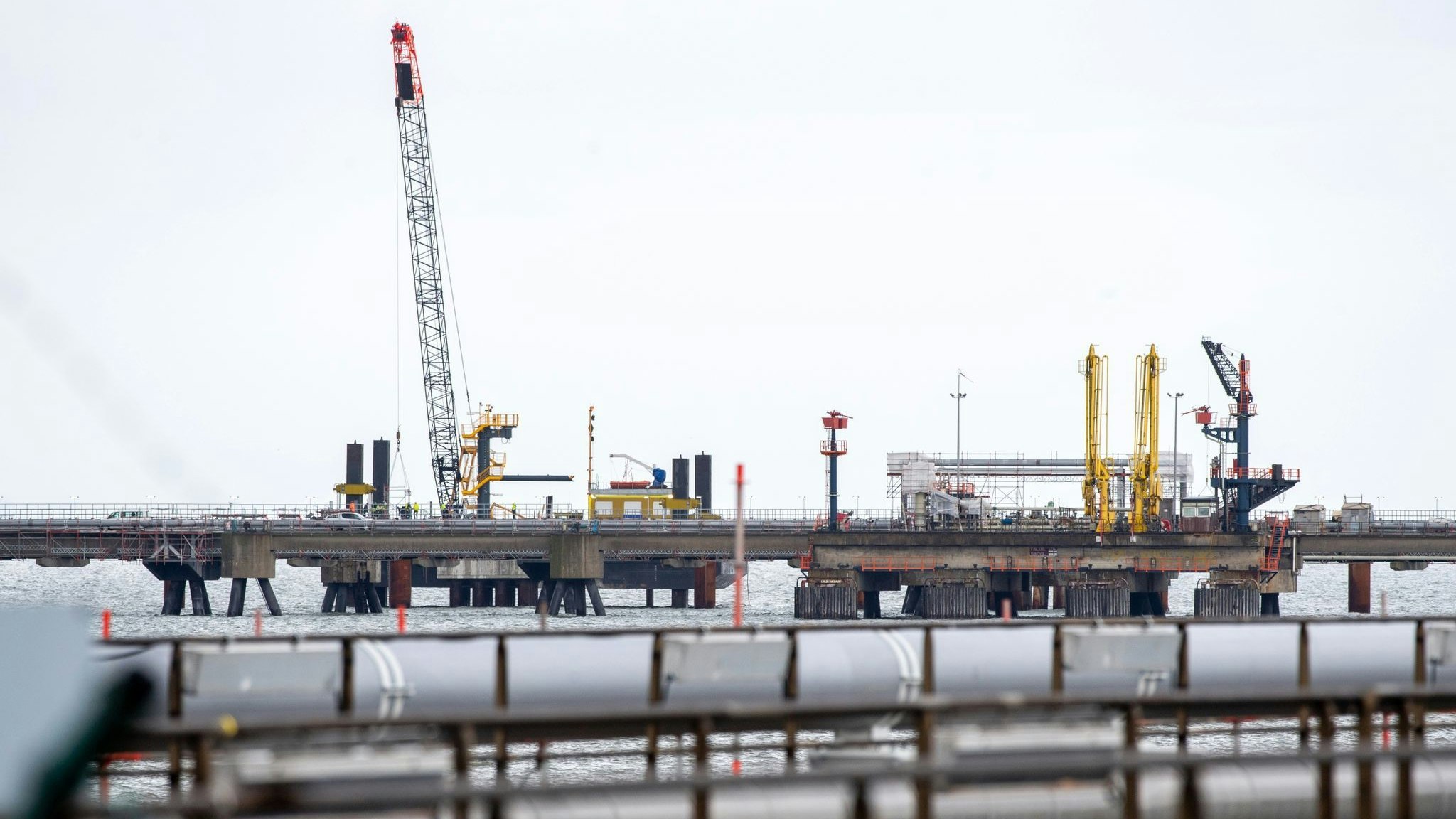 Technische Anlagen und ein Kran stehen auf dem Anleger für das LNG-Terminal in der Nordsee vor Wilhelmshaven. Foto: dpa/Dittrich