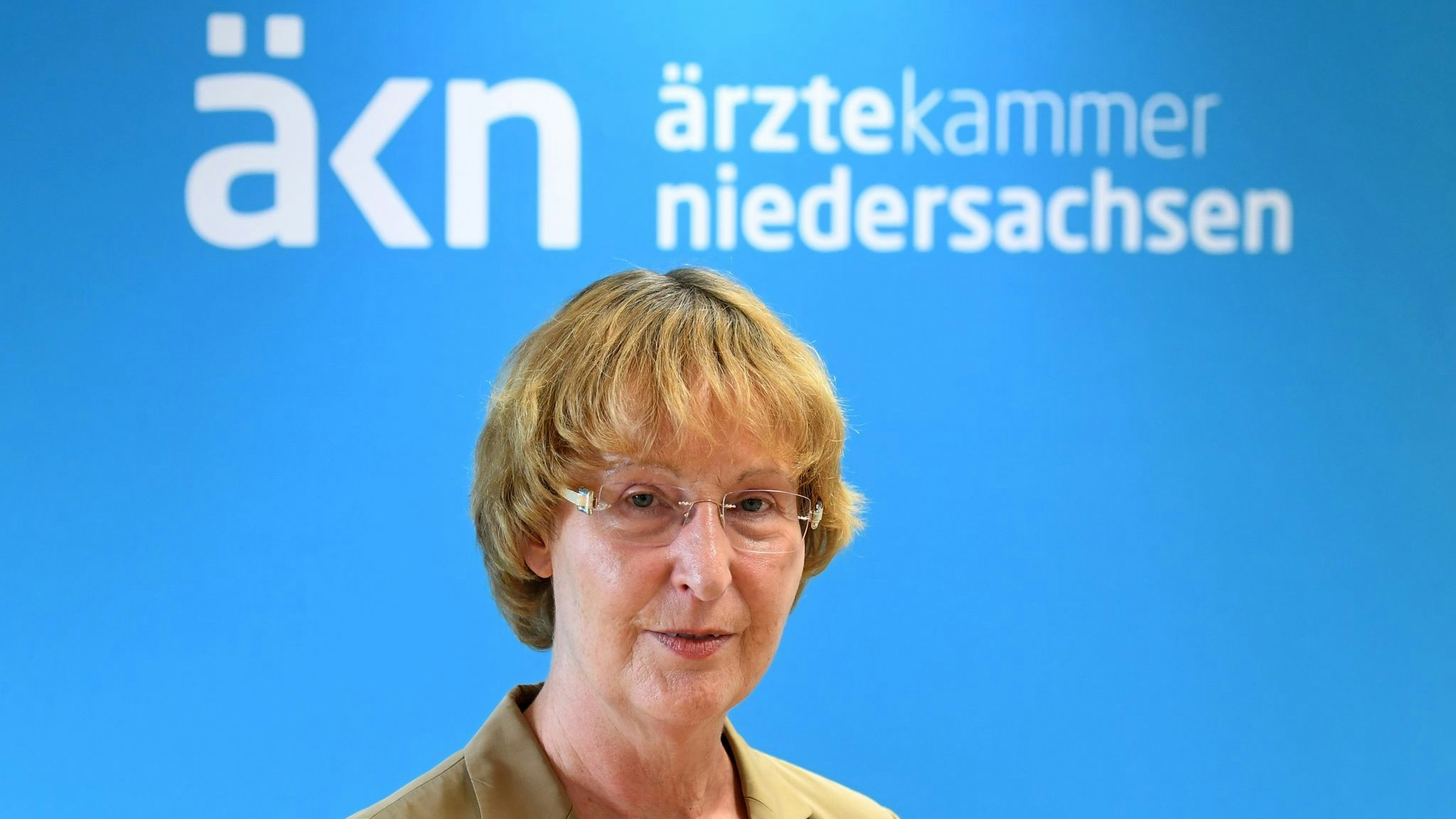 Ärztekammer-Präsidentin Martina Wenker steht während eines dpa-Gespräches vor dem Logo der Ärztekammer Niedersachsen. Foto: dpa/Hollemann
