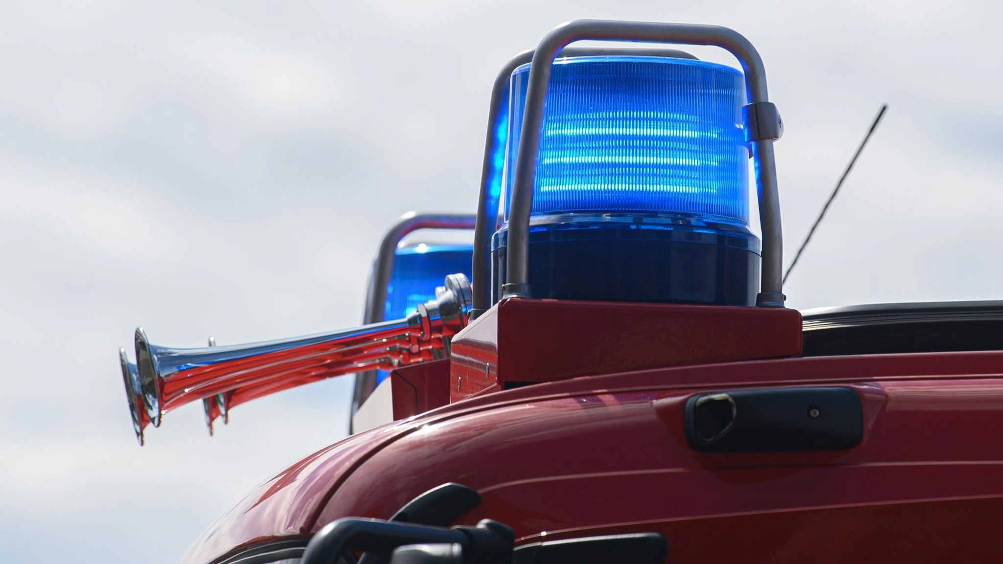 Blaulichter leuchten auf dem Dach eines Einsatzfahrzeugs der Feuerwehr. Foto: dpa/Michael