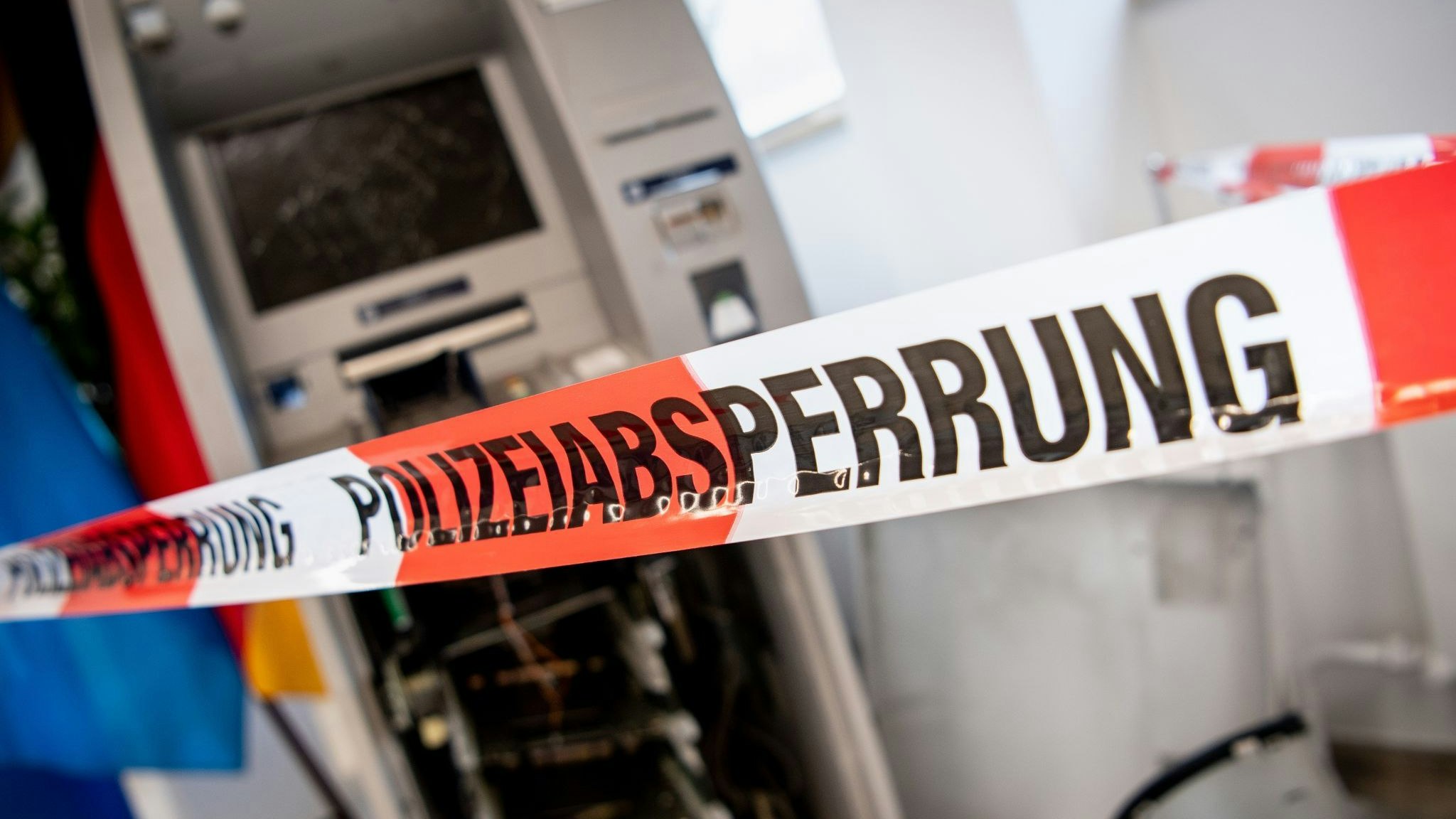 Ein gesprengter Geldautomat ist hinter einem Flatterband mit der Aufschrift „Polizeiabsperrung“ zu sehen. Foto: dpa/Balk