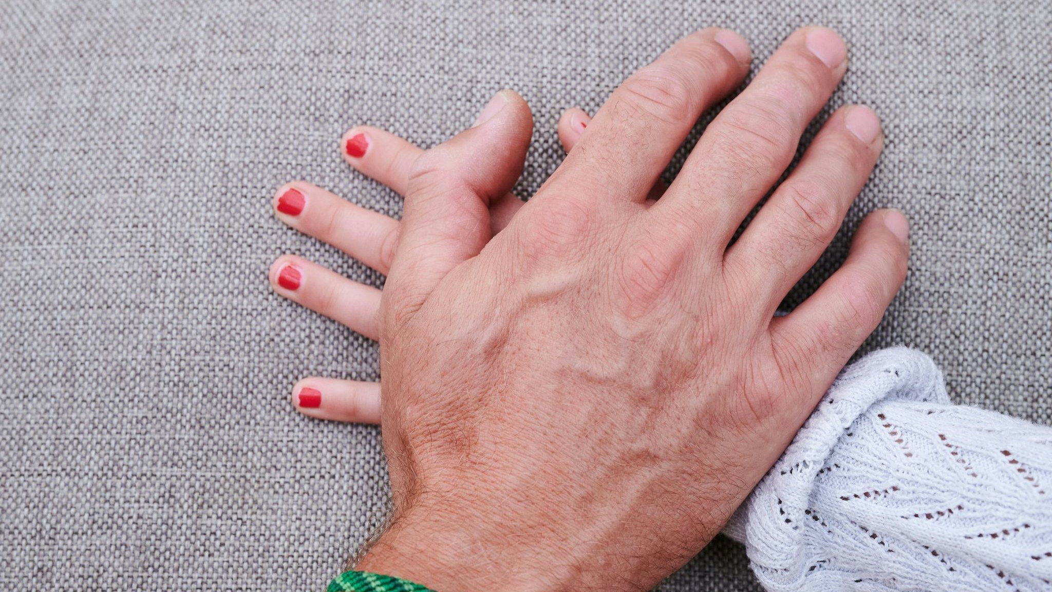 Eine Männerhand liegt auf einer Mädchenhand(gestellte Szene). Foto: dpa/Riedl
