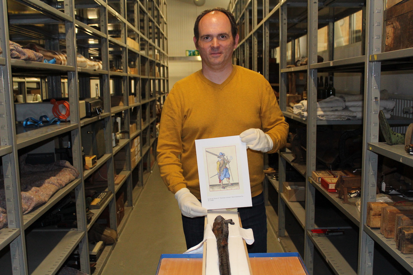 Museumsleiter Kai Jansen mit der Kopie einer historischen Abbildung, auf der eine Arkebuse zu sehen ist. Foto: Heinzel