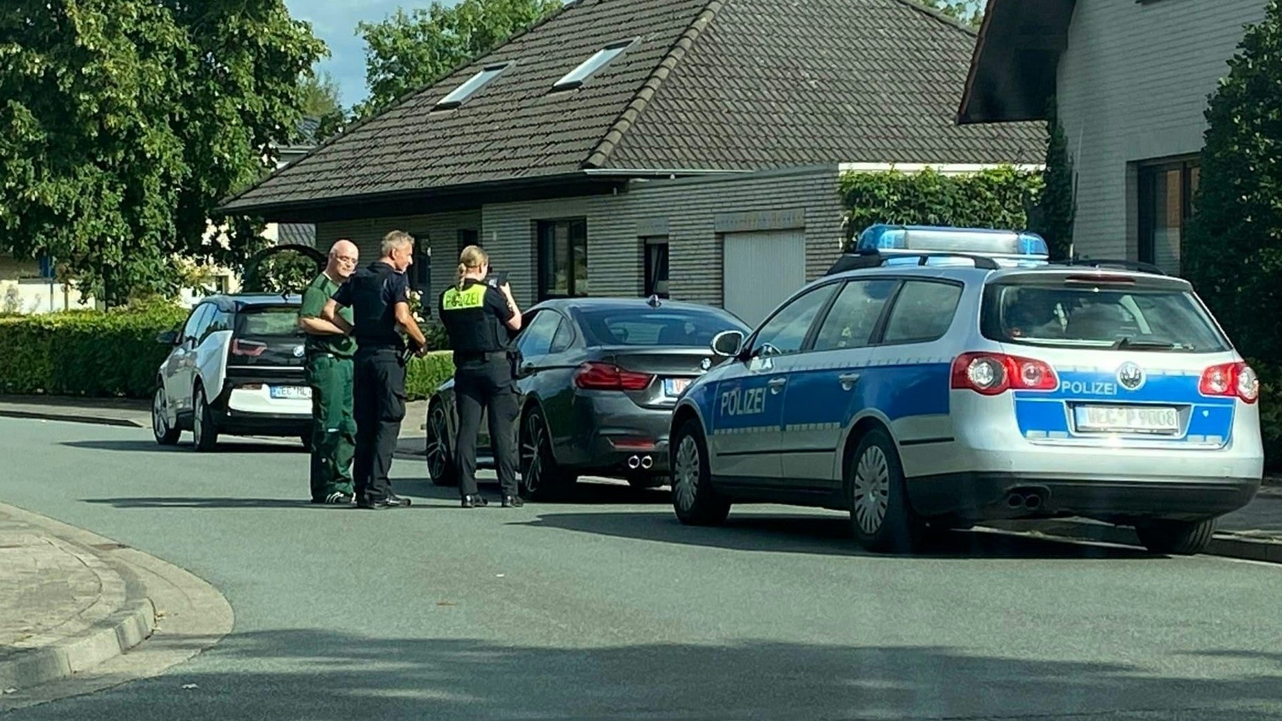 Gestoppt, gestellt und festgenommen: Polizeibeamte und Autohändler stehen vor dem BMW. Noch sitzt der Fahrer darin. Kurz danach wird er in Handschellen abgeführt. Foto: Facebook