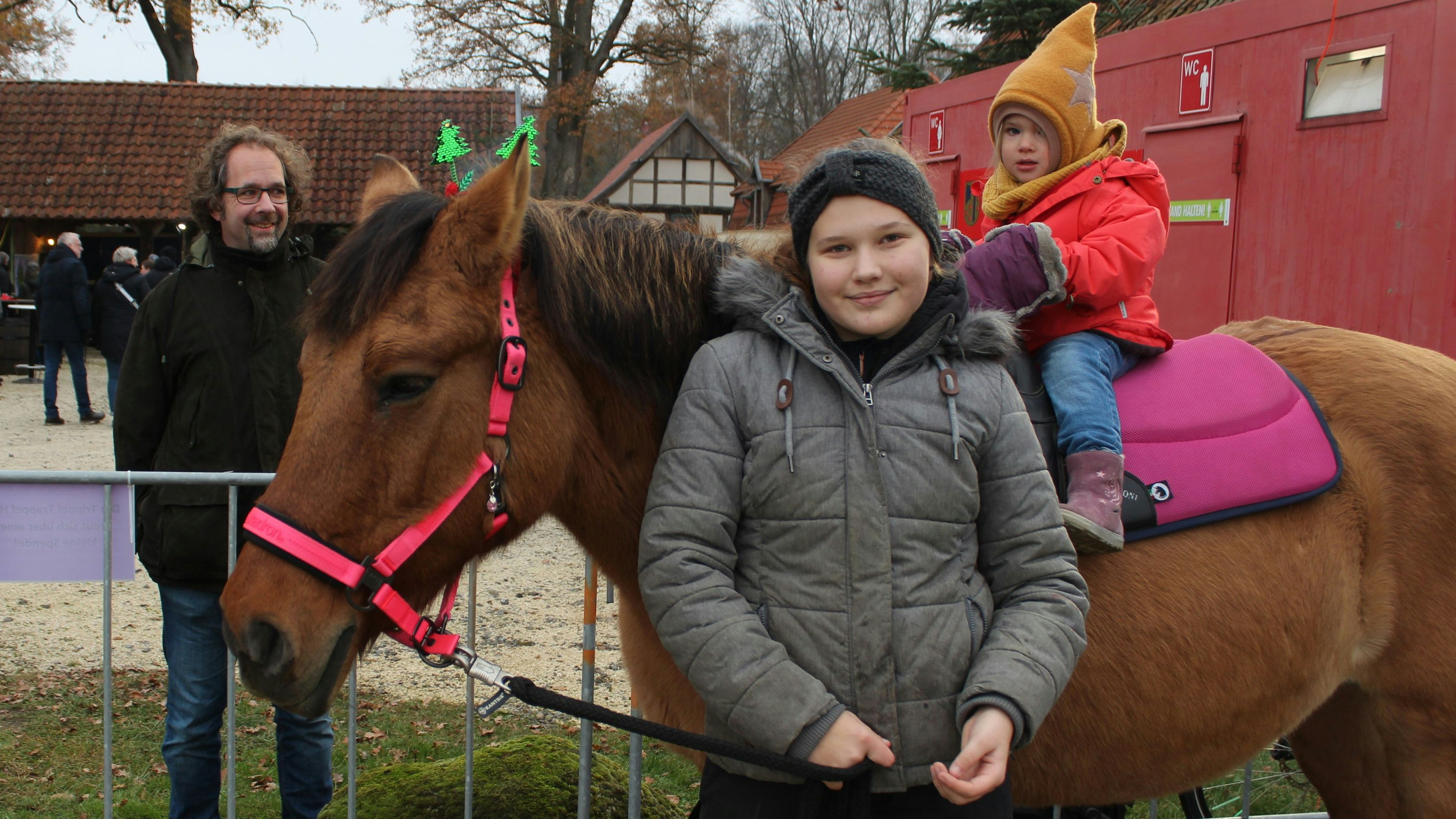 Vater Hans-Ulrich Otto (links) beobachtet stolz wie Tochter Thea (rechts) auf Stina reitet. Geführt wird das Pferd von Leonie Kohl vom Trippel Trappel Hof. Foto: Heinzel