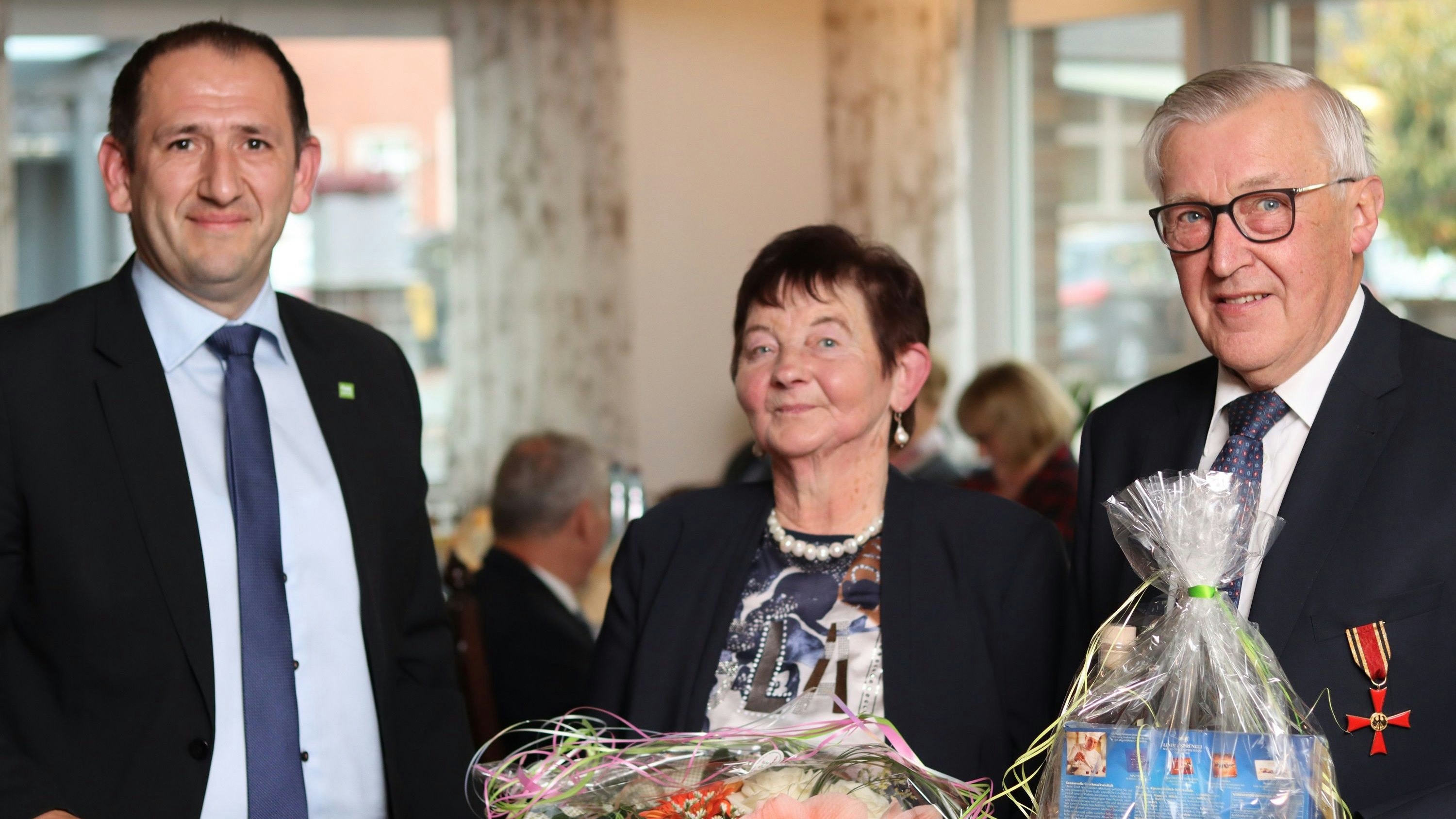 Ausgezeichnet: Antonius Lamping (rechts) erhält das Bundesverdienstkreuz. Molbergens Bürgermeister Witali Bastian (links) gratulierte Lamping und seiner Frau Gertrud. Foto: Landkreis Cloppenburg / Rühl