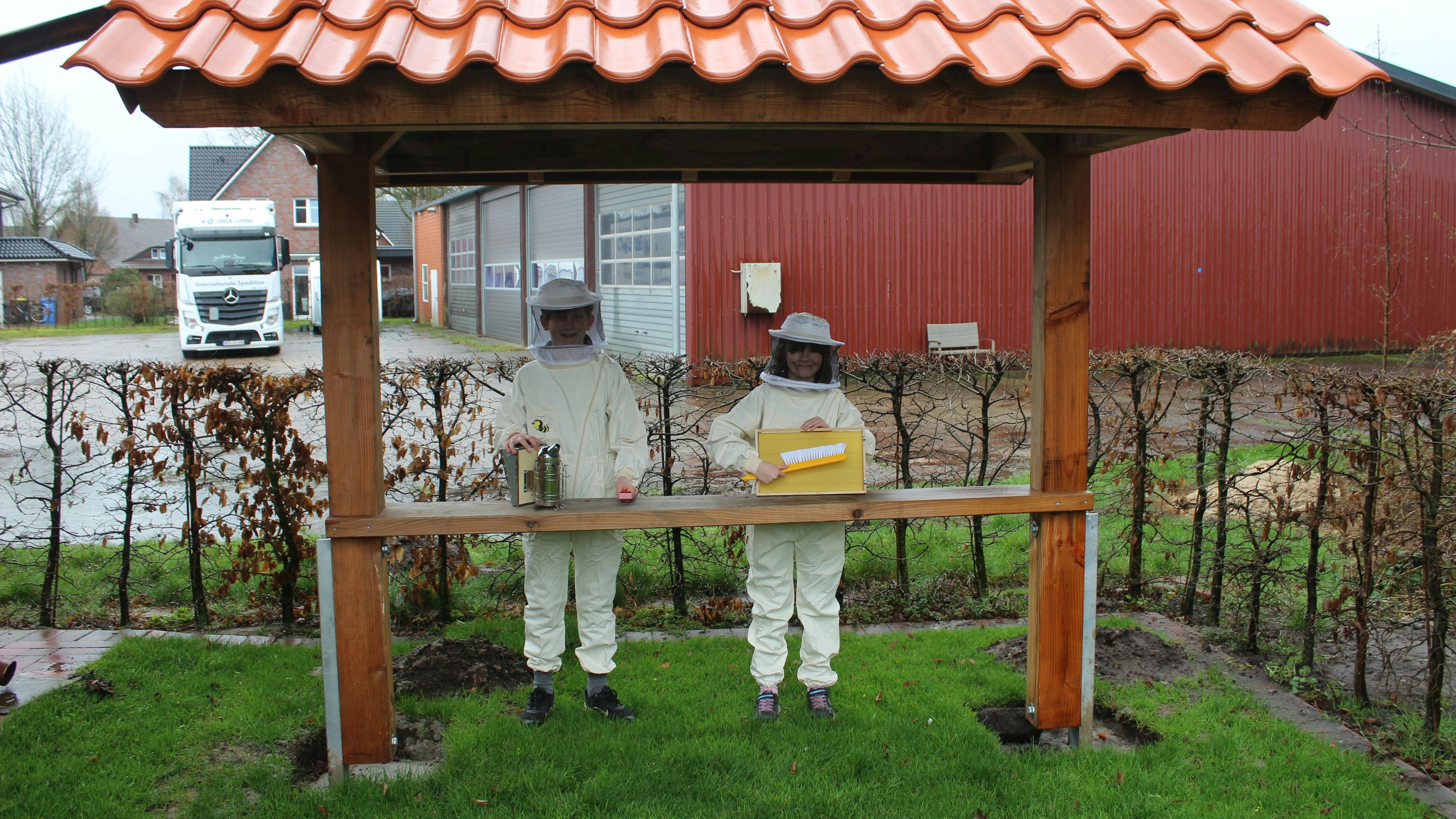 Henk Niemöller (links) und Lotte Klaas (rechts) am künftigen Wohnort der Bienenvölker mit dem Equipment der Schulimkerei. Foto: Heinzel