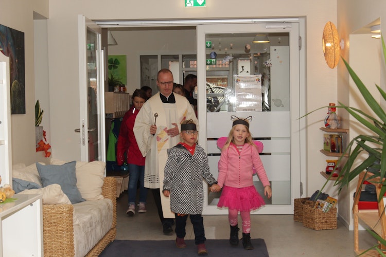 Feierlich eingeweiht: Die Kindergarten-Kinder begleiten Dechant Berthold Kerkhoff bei der Segnung des Kindergartens. Foto: Kindergarten St. Josef