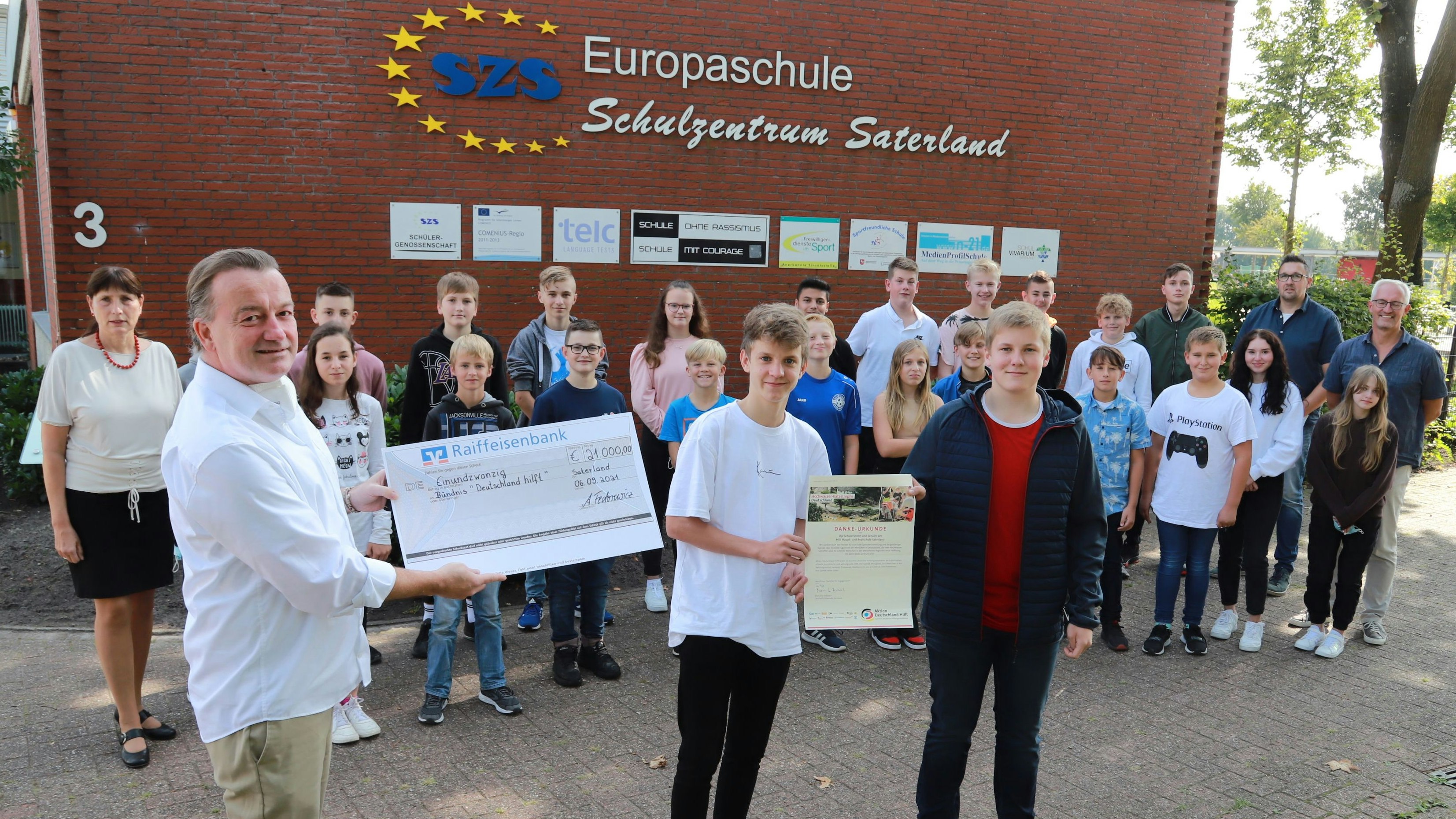 Die Schülerinnen und Schüler der Haupt- und Realschule Saterland überreichten den symbolischen Scheck an Joachim Graf von Arnim. (links). Foto: C. Passmann