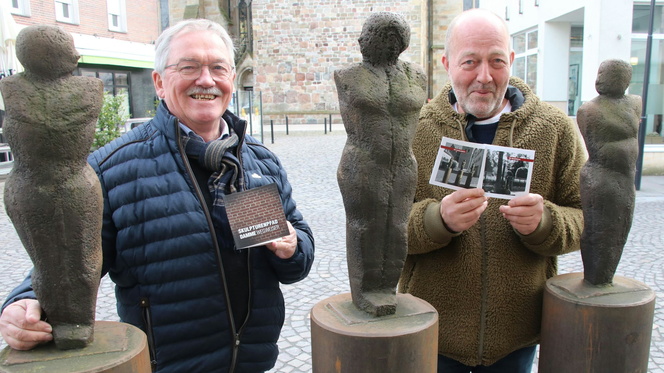 Zufriedene Gesichter: Heiko Bertelt (links) und Norbert Enker präsentieren vor der Skulptur "Seitenblick" den neuen Wegweiser über den Dammer Skulpturenpfad. Foto: Lammert