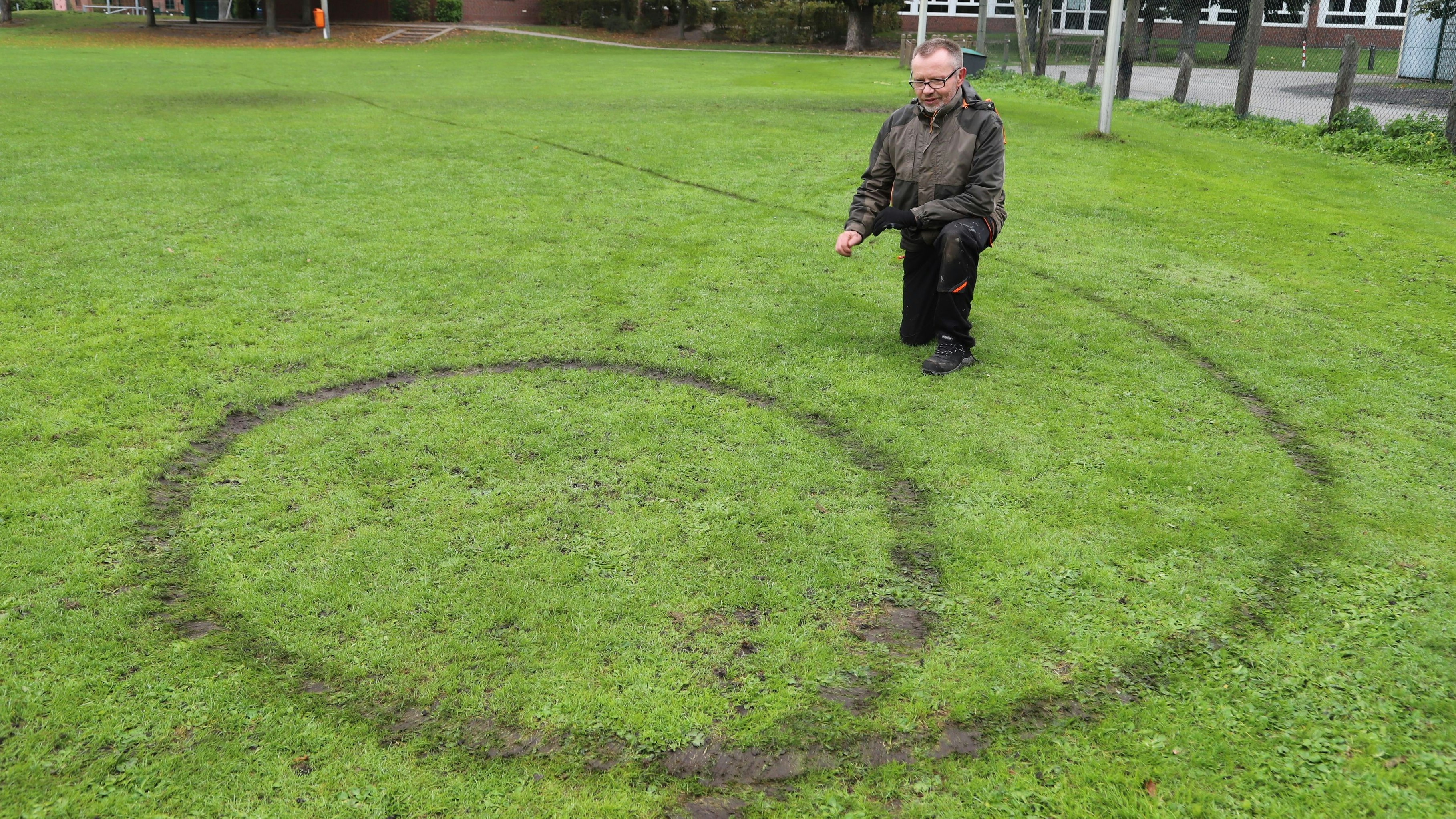 Ärgernis: Oscar Büscherhoff ist entsetzt über die beschädigte Grasnarbe auf dem Sportplatz bei der Marienschule. Foto: Passmann
