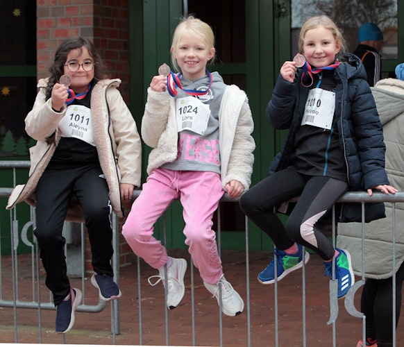 Stolze Finisherinnen: Drei Teilnehmerinnen des Bambini-Laufs präsentieren der Fotografin ihre Medaillen.