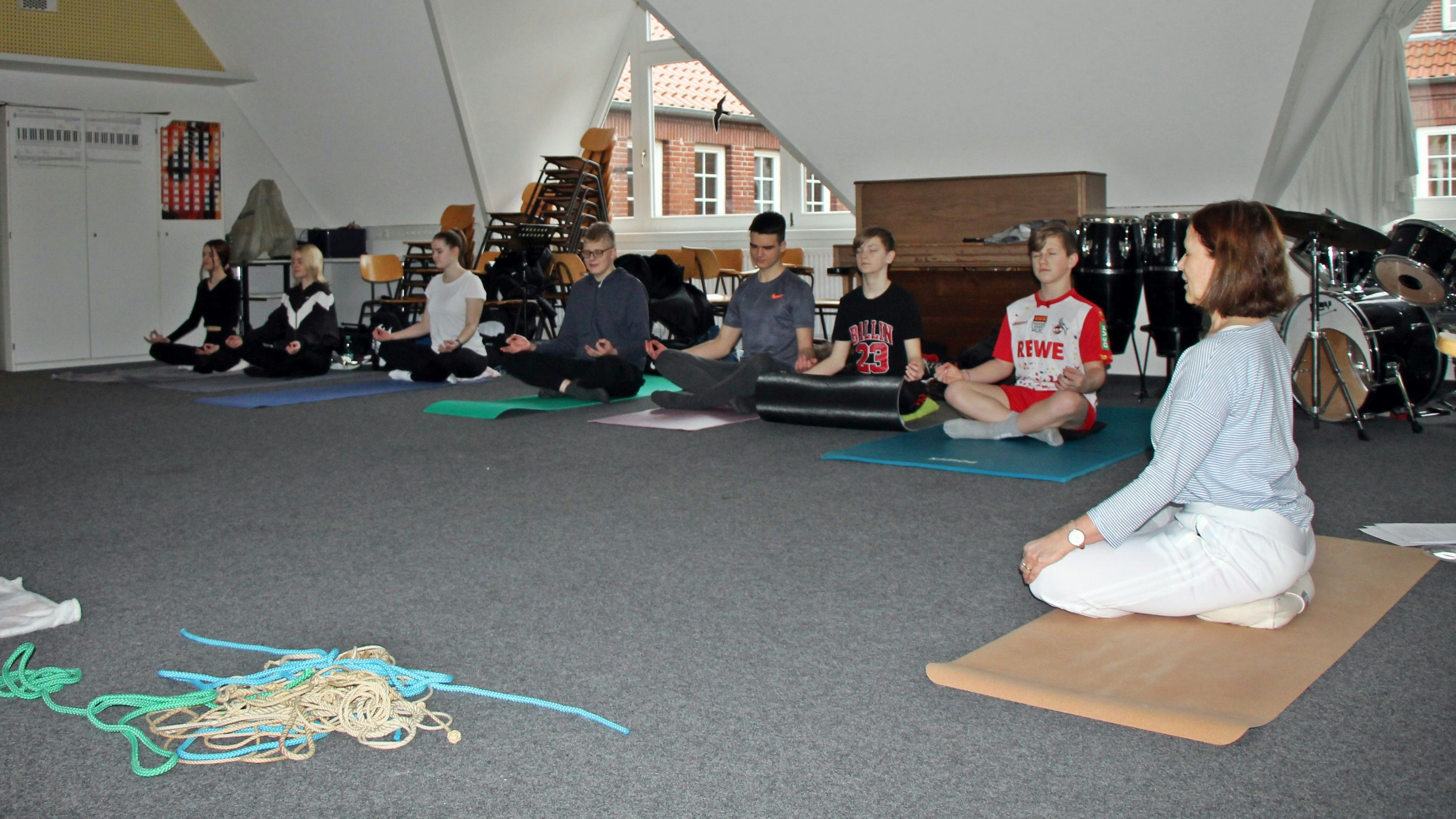 Kraft durch Ruhe: Kerstin Kröger (rechts) taucht mit den Jugendlichen in die Welt des Yoga ein. Foto: Oevermann