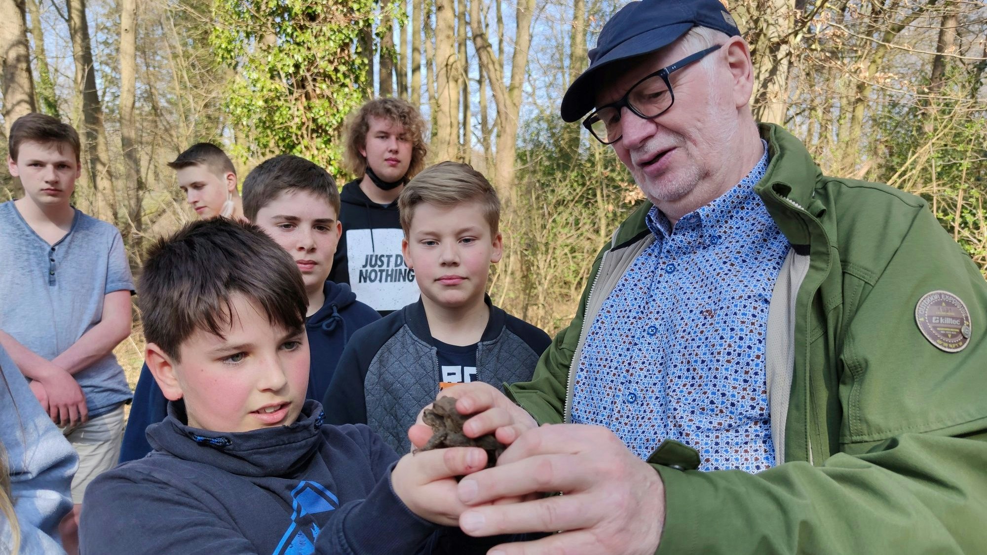 Unterricht zum Anfassen: Bernard Schonhöft gibt den Schülern behutsam ein Erdkröten-Pärchen in die Hände. Foto: Röttgers