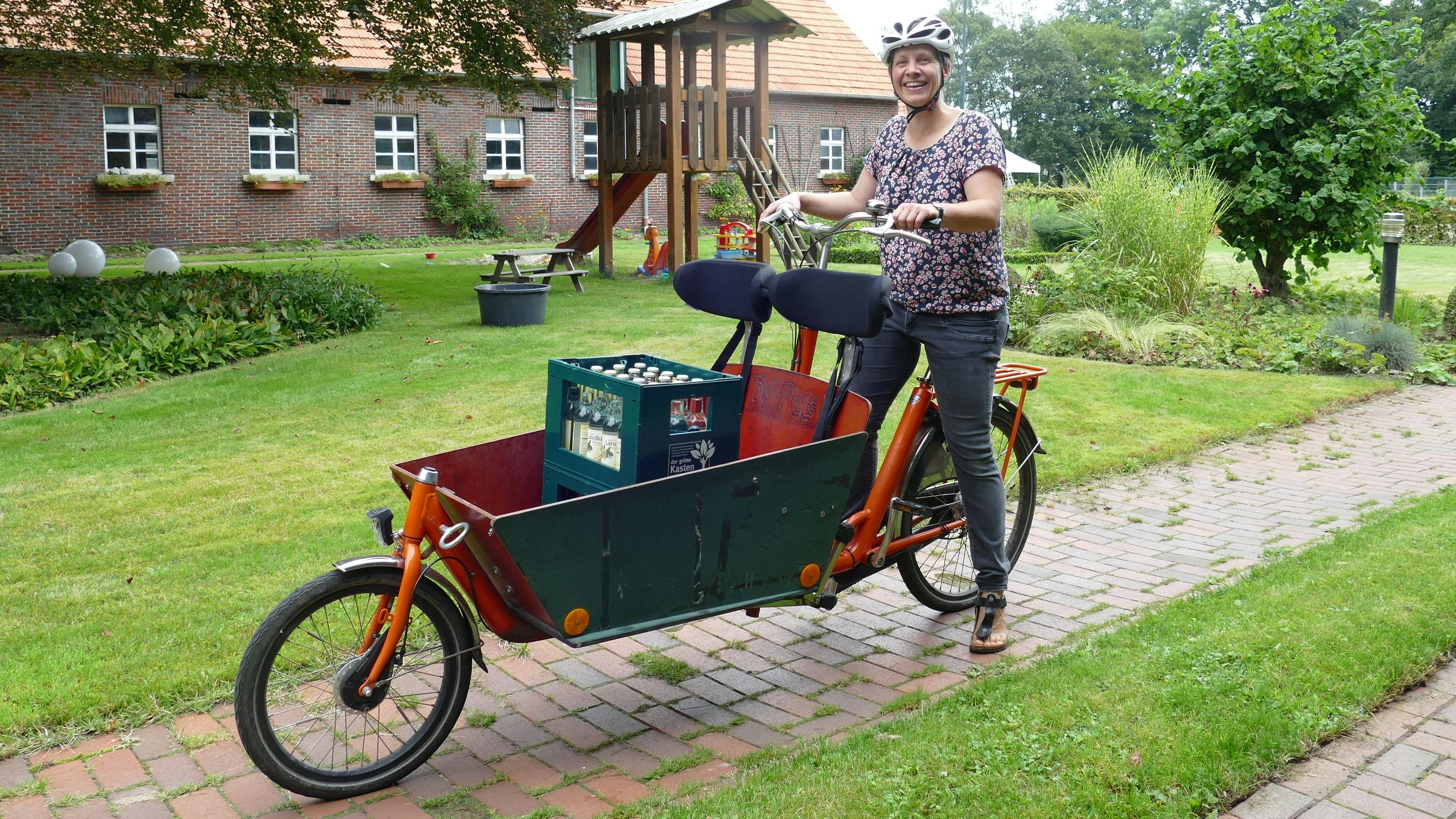 Modifiziertes Lastenrad: Anne Lang vom Gut Altenoythe fährt mit dem Bakfiets nicht nur Getränkekisten durch die Gegend, sondern dank eigens montierter Kopfstützen auch die Kinder in die Kita.&nbsp; Foto: Stix