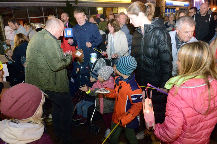 Großer Andrang: Am Laternenumzug nahmen zahlreiche Familien teil. Marktmeister Jörn Willen (links) verteilt Lebkuchenherzen. Foto: Siemer