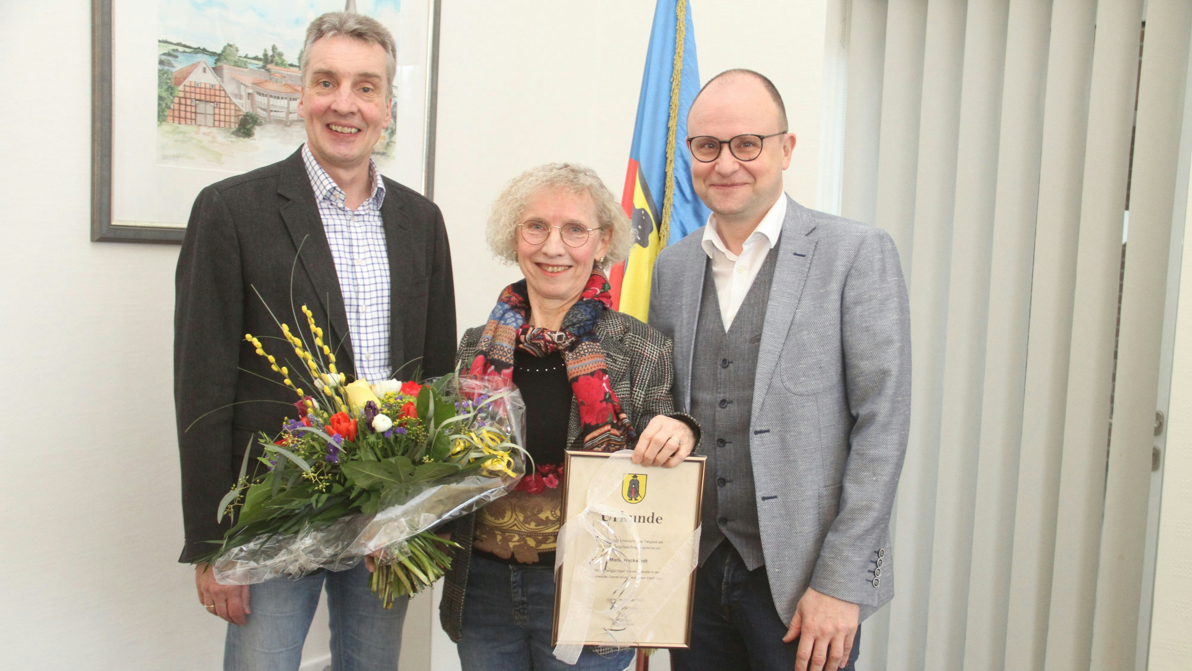 Seit 25 Jahren im Amt: Erster Gemeinderat Karl-Heinz Focken (links) und Bürgermeister Thomas Höffmann gratulieren der Gleichstellungsbeauftragten Maria Hackstedt. Foto: Danke