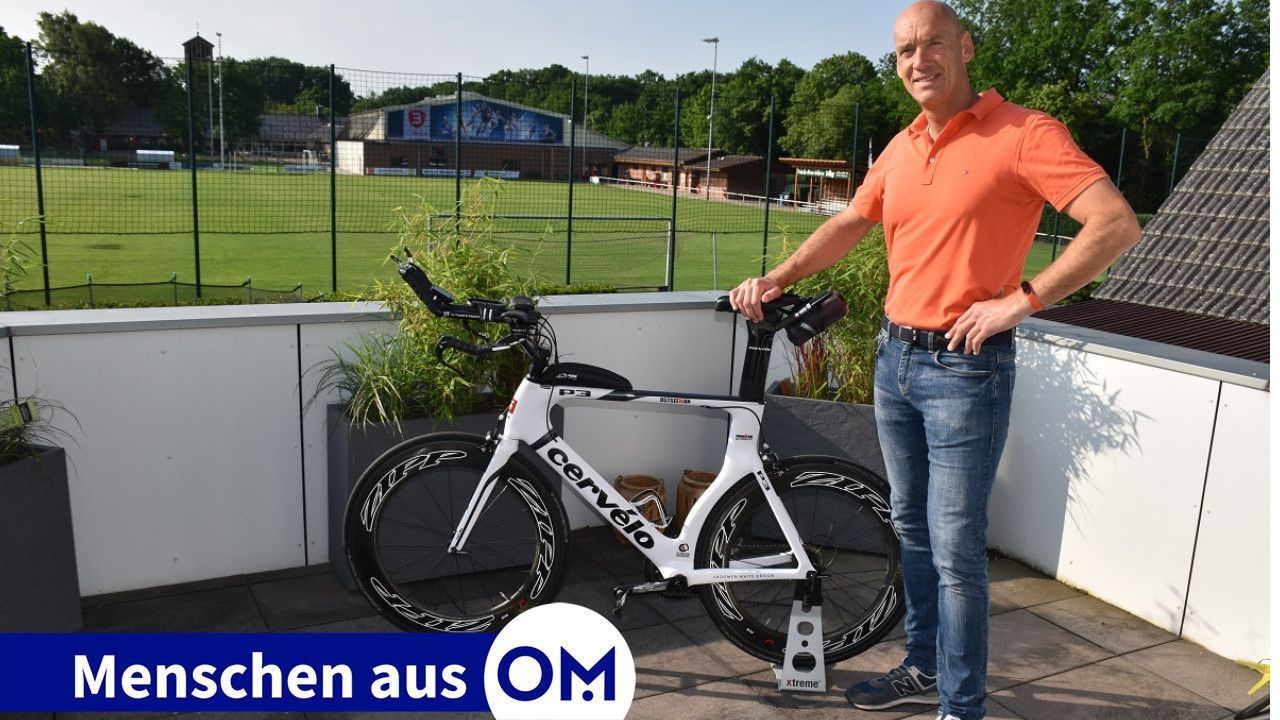 Wohnort direkt am Stadion: Markus Vocks mit seinem Rennrad und dem Sportplatz sowie der Sporthalle des SV Handorf-Langenberg im Hintergrund. Foto: Klöker