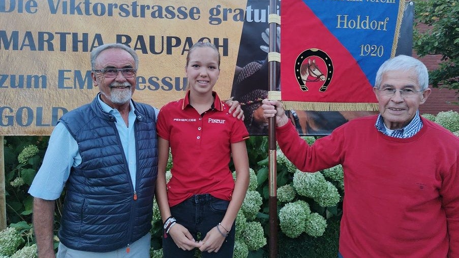 Ein schöner Empfang: Martha Raupach mit Nachbar Helmut Wolf (links) und Dr. Aloys Brandt vom RuFV Holdorf. Foto: Röttgers