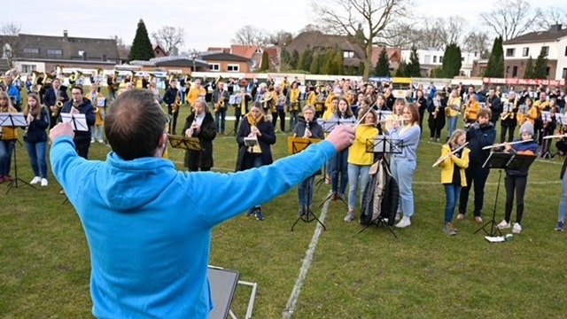 Niko Förster dirigiert die mehr als 200 Musiker im Fußballstadion in Oythe. Foto: M. Niehues