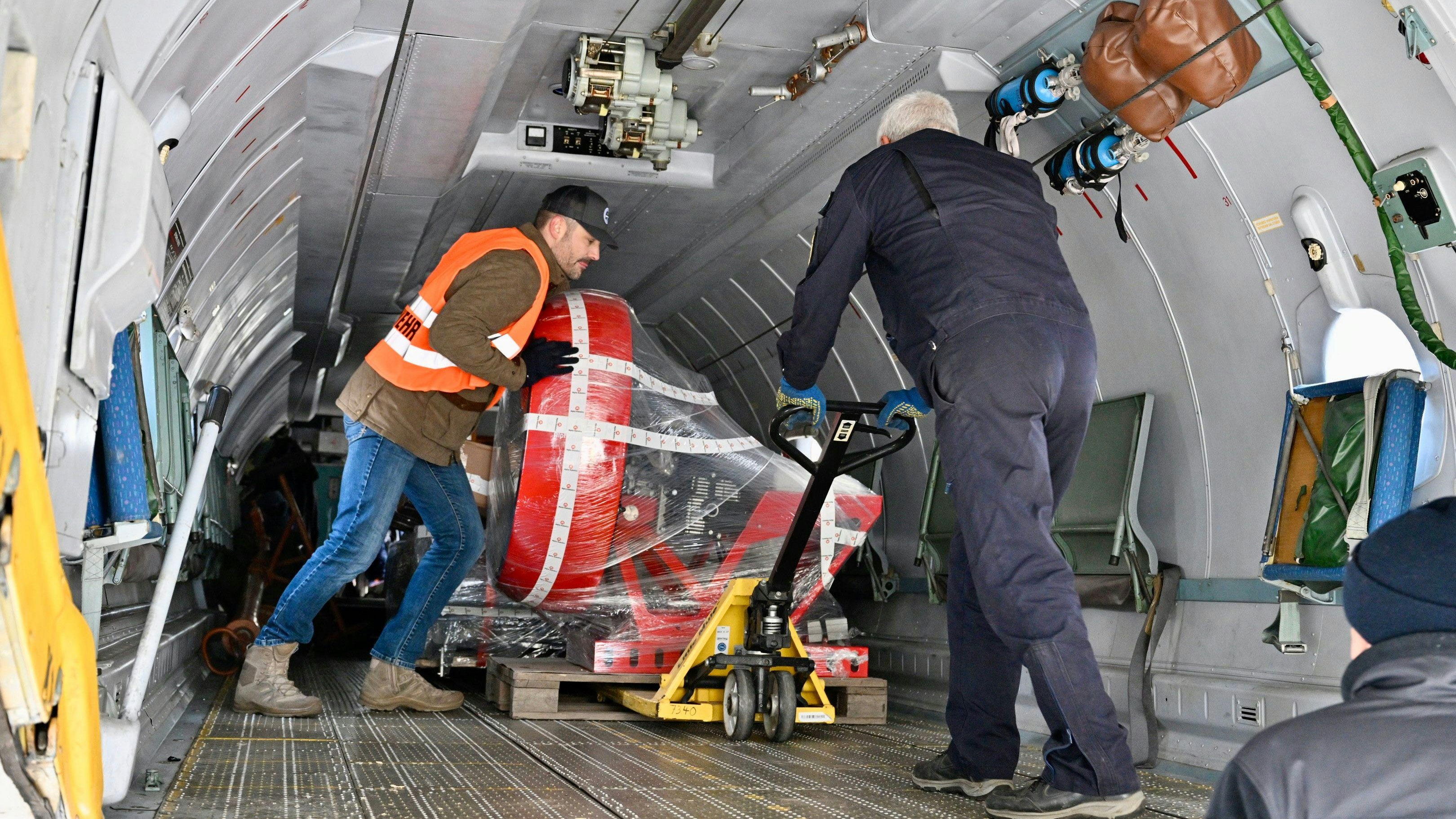 Oliver Rasche packt mit an: Das schwere Feuerwehr-Equipment wird ins Flugzeug verfrachtet. Foto: M. Niehues