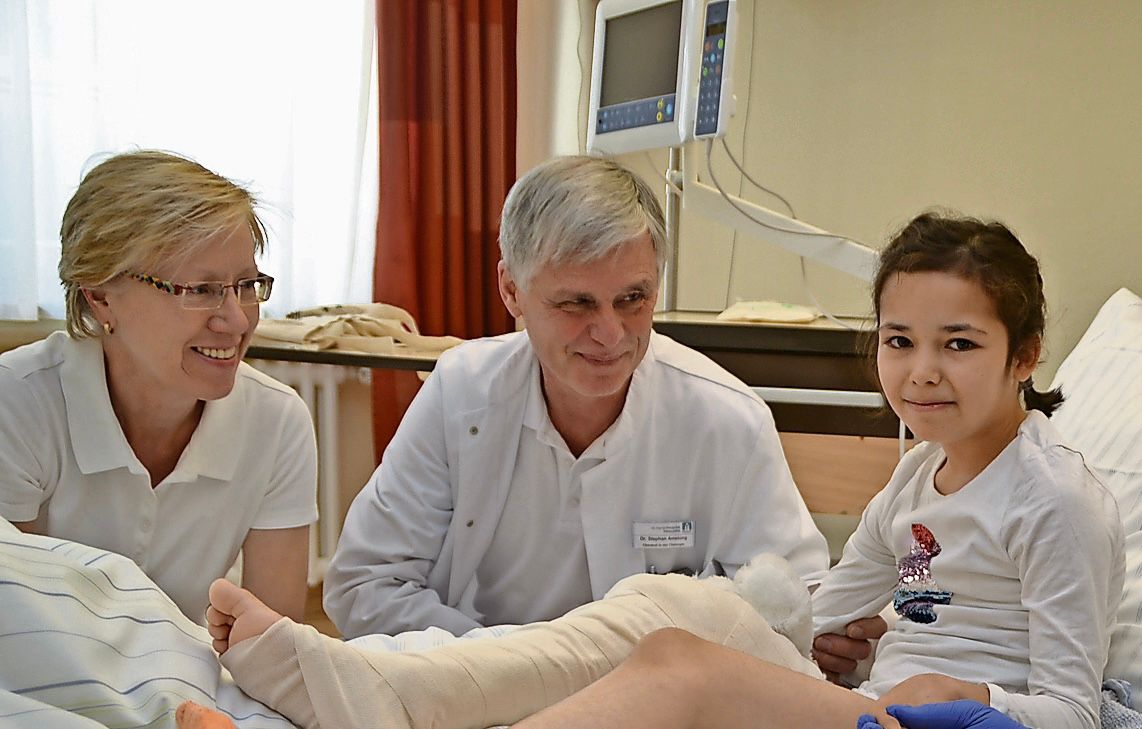 In guten Händen: Die junge Patientin Toba mit den Medizinern Dr. Gabriele Schmitz und Dr. Stephan Amelung. Foto: Wimberg<div></div>
