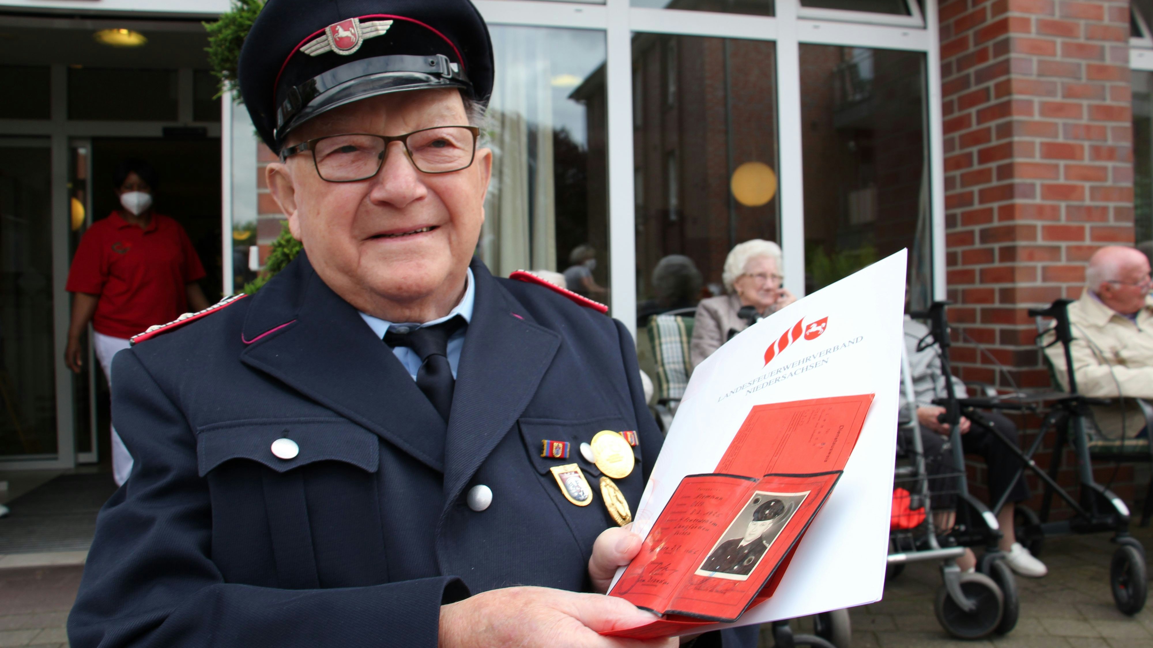 Otto Niemann kann auf die Auszeichnung für seine langjährige Mitgliedschaft stolz sein. Neben der Urkunde hält der Jubilar seinen uralten Feuerwehrausweis in den Händen. Foto: Speckmann