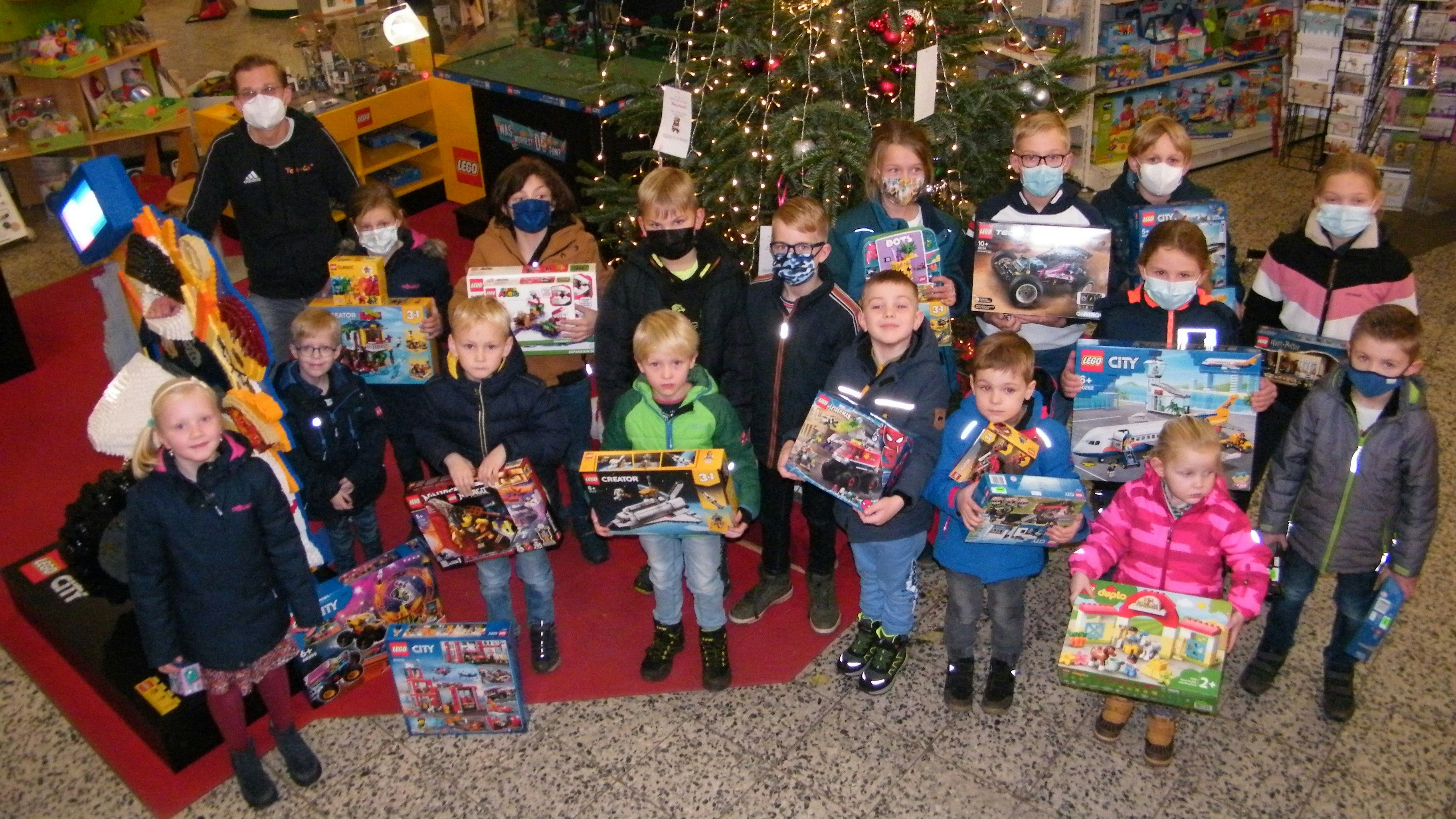 Treffpunkt Weihnachtsbaum: "Toys &amp; Co."-Inhaber Henrich Römann (hinten links) freut sich mit einigen der Kinder, die beim Lego-Bauwettbewerb des Vereins "Wir Lohner" gewonnen haben. Foto: Gerwanski