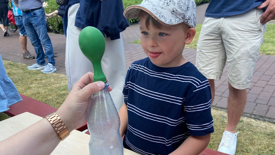 Große Augen: Der kleine Mats staunt, als ihm Erzieherin Melanie zeigt, wie ein Luftballon aufgeblasen werden kann, ohne hineinzupusten. Foto: Hoff