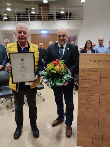 Urkunde und Blumen: Mr. Basketball Horst Maronn (links) erhält vom stellvertretenden Bürgermeister und Ratsvorsitzenden, Rainer Duffe, den diesjährigen Bürgerpreis. Foto: Röttgers