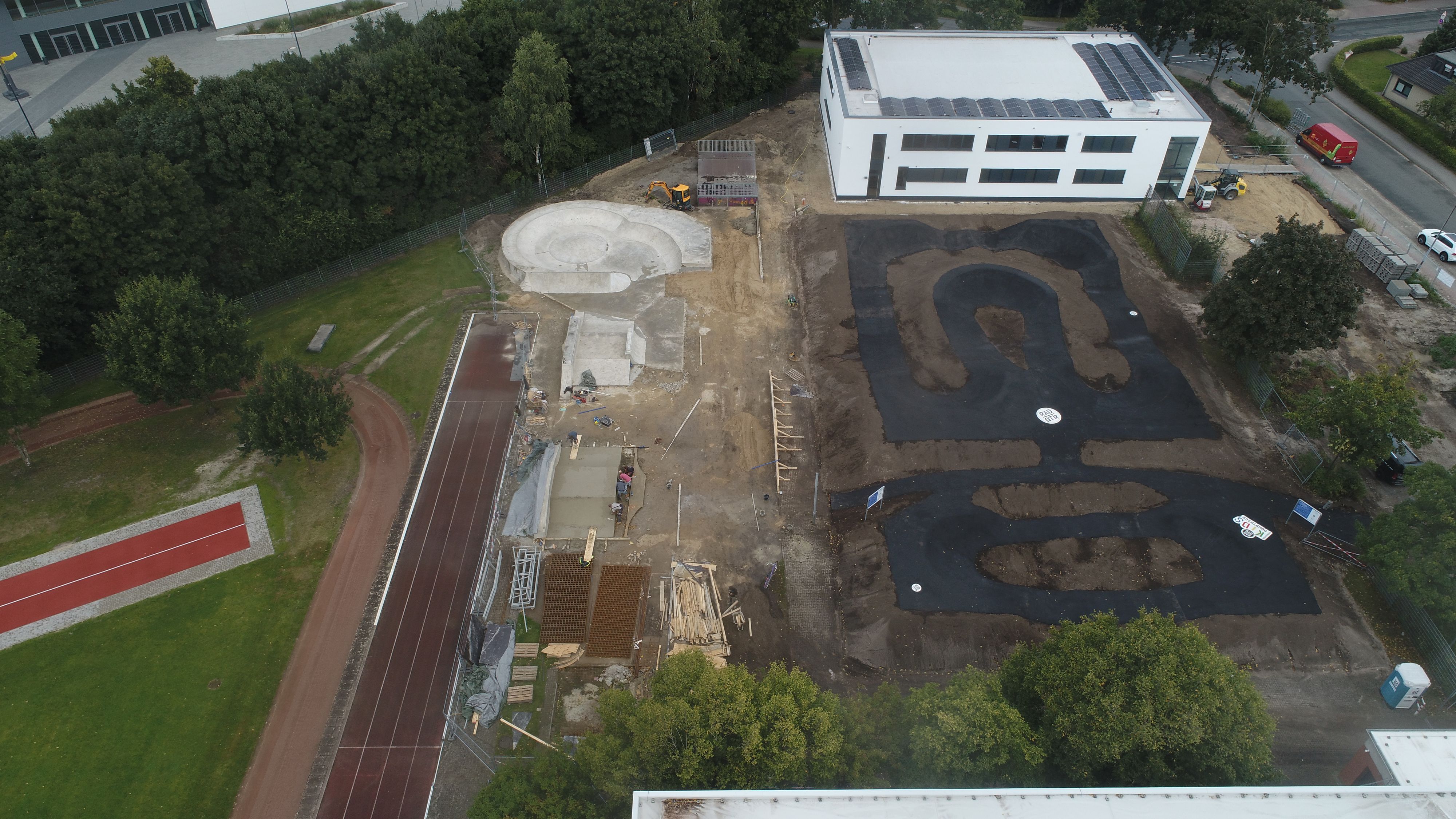Die neue Anlage von oben: Links sind die Arbeiten an der Skateparksanierung zu sehen, rechts ist die Asphaltfläche des Pumptracks bereits fertiggestellt. Foto: RadQuartier GmbH