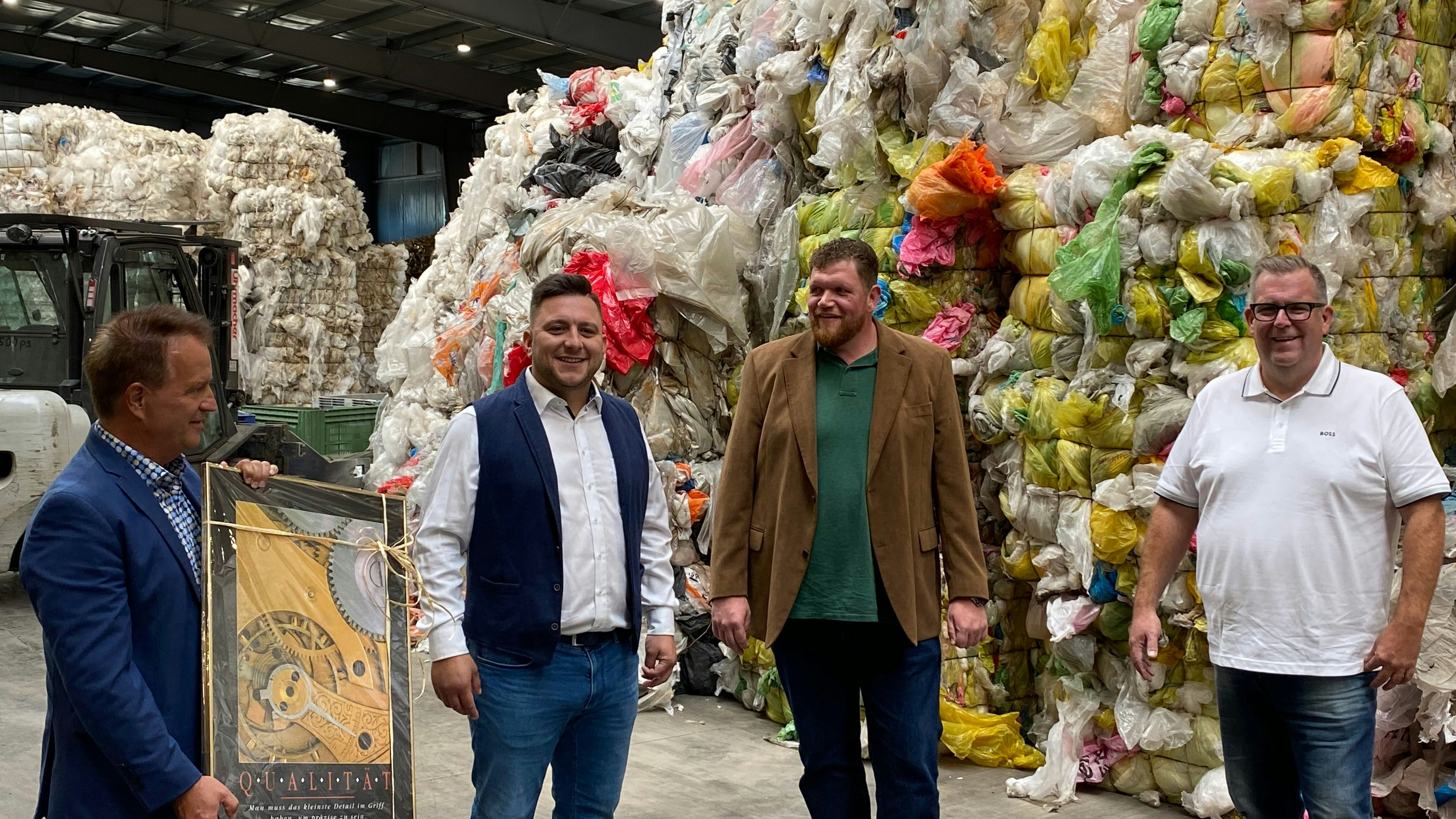 Besichtigung: Mit einem Präsent im Gepäck traf sich Bösels Bürgermeister Hermann Block mit den Geschäftsführern Deniz Kanil, Arne Koch und Heiko Lappe in der Recycling-Firma (von links). Foto: Wimberg