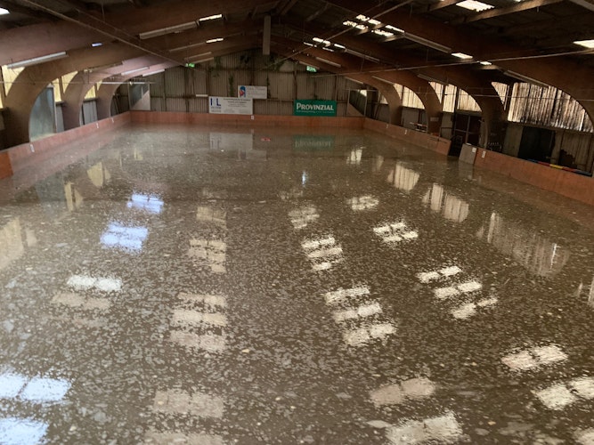 Das Licht spiegelt sich im Boden: Die Halle des Reit- und Fahrvereins Bochum-Werne stand nach der Flut unter Wasser. Foto: Verein