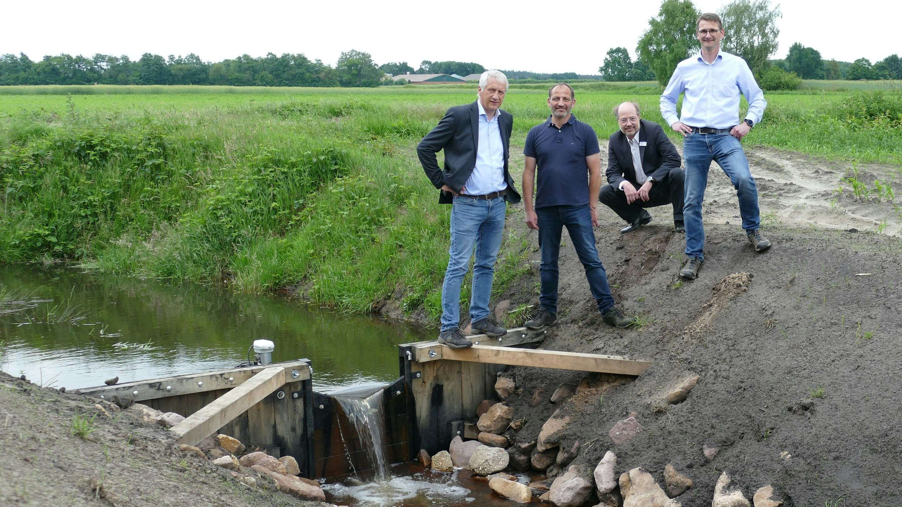 Sperrwerk im Friesoyther Moor: Martin Windhaus (Wasseracht), Elmar Preut (Landwirt) sowie Stefan Kraus und Uwe Sütering vom OOWV sind auf die Ergebnisse des Wasserprojekts gespannt. Foto: Stix