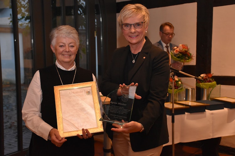 Bürgermeisterin Manuela Honkomp (rechts) überreicht Agnes Bünker eine Urkunde und die Ehrengabe aus Glas der Gemeinde Steinfeld. Foto: Timphaus