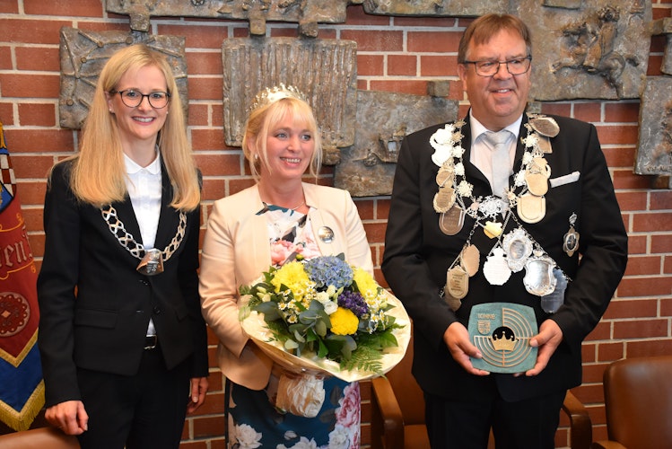 Bürgermeisterin Dr. Henrike Voet übergibt einen Blumenstrauß und den Königsschild der Stadt Lohne an das Königspaar Annette und Hans-Dieter Honkomp. Foto: Timphaus
